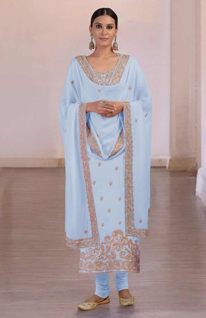 A woman models a light blue kurta set with intricate gold embroidery.