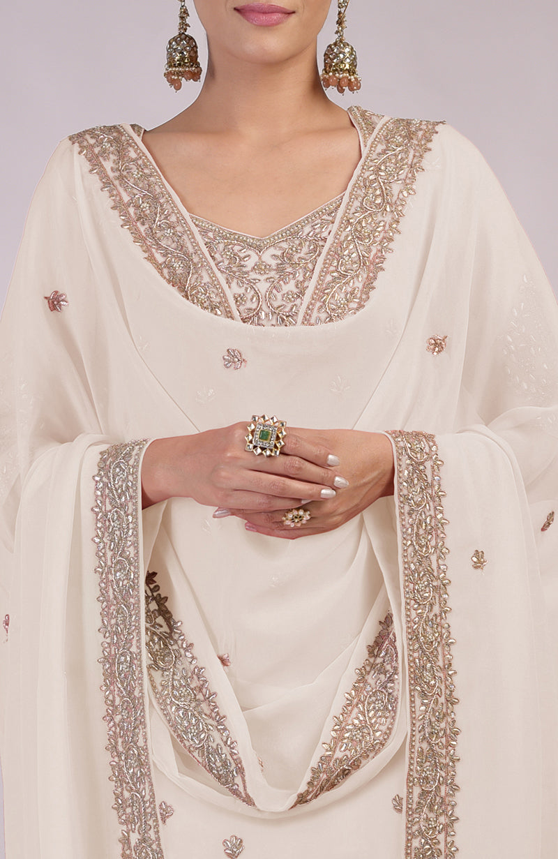 A woman models a sea salt kurta set with intricate rose gold embroidery.