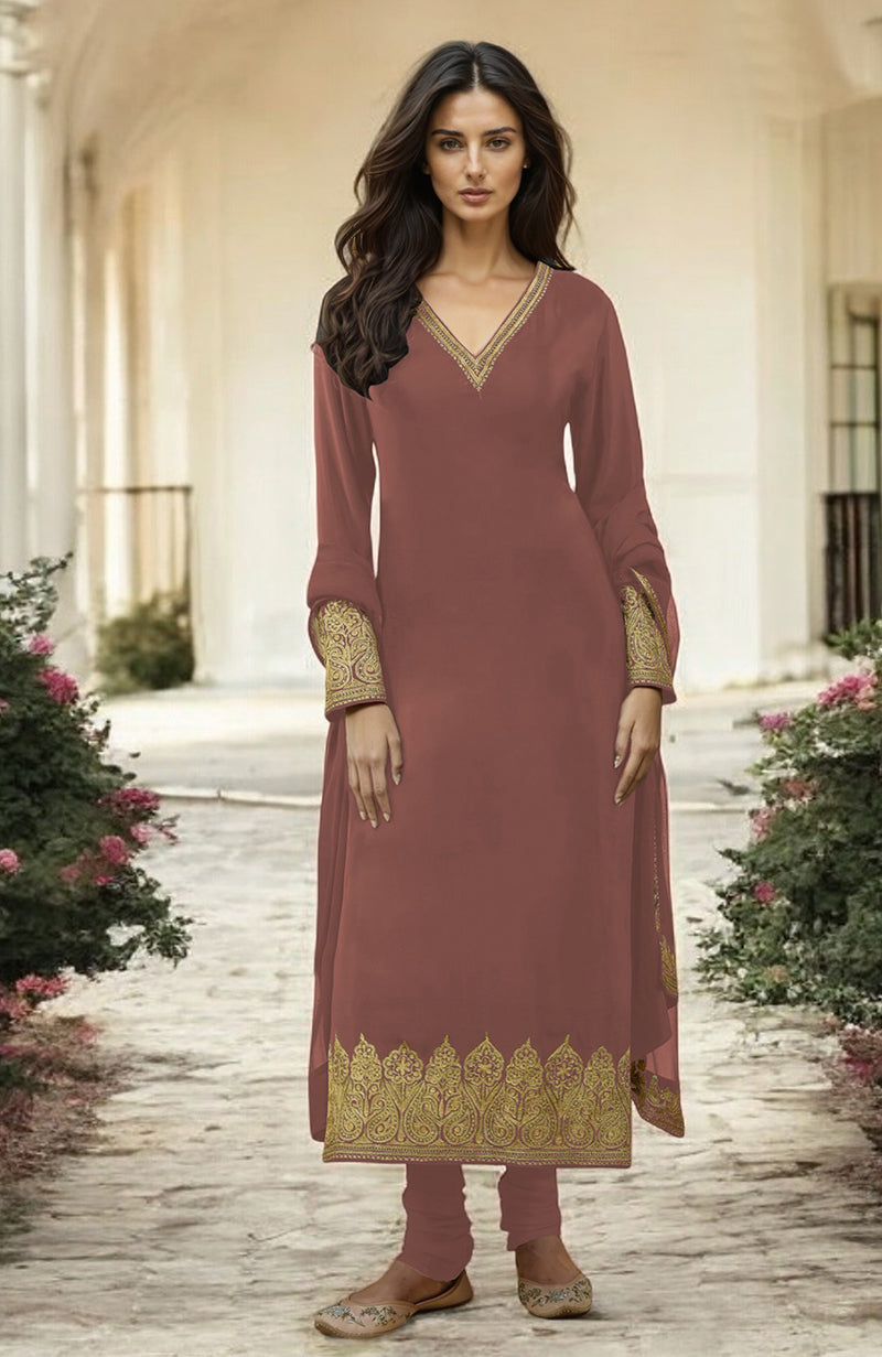 A woman models a long, rust-colored kurta set with gold embroidery.