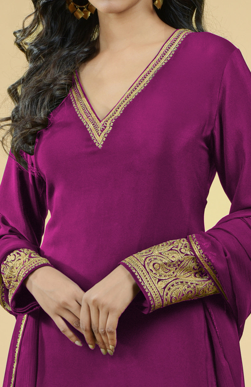 A woman models a fuchsia kurta set with gold Kashmiri tilla aari embroidery.