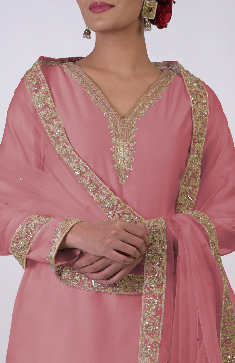 A woman models a withered rose kurta set with gold embroidery and a matching dupatta.
