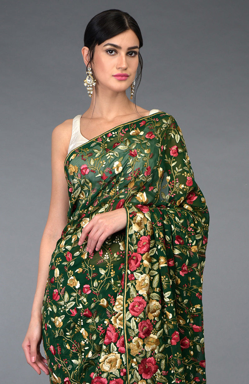 Emerald green Parsi Gara hand embroidered saree with floral patterns.