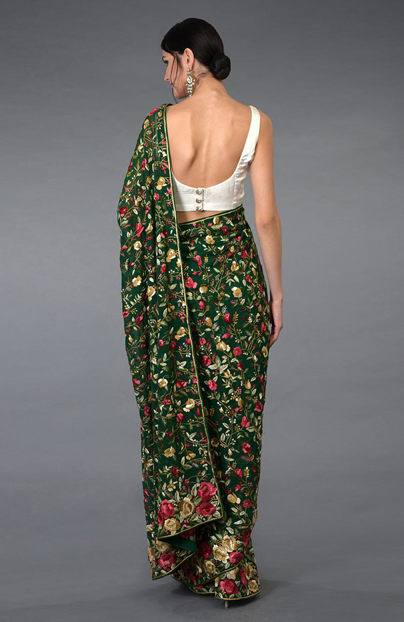 Emerald green Parsi Gara hand-embroidered saree with floral patterns.