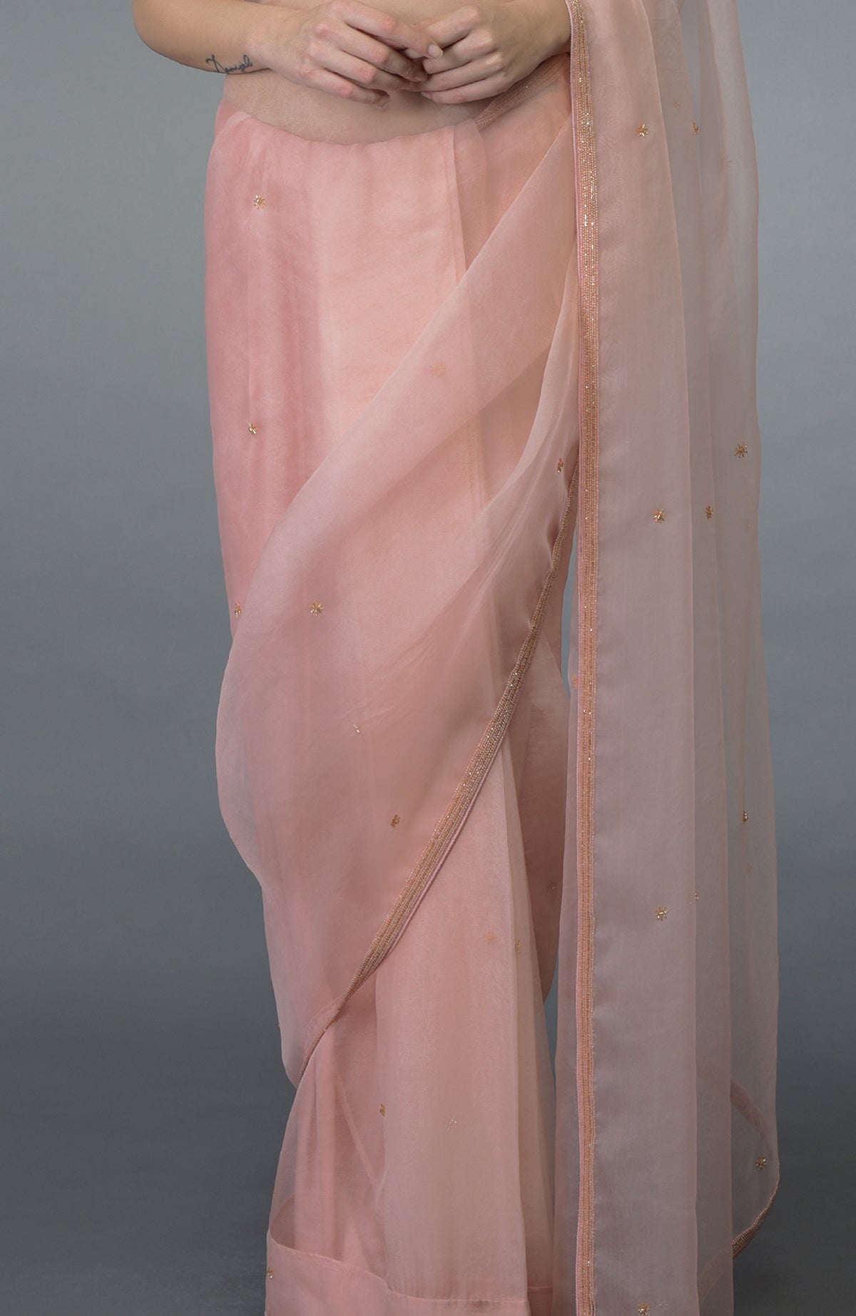 Pastel peach organza silk saree with bead embroidery and sprinkled bootahs.