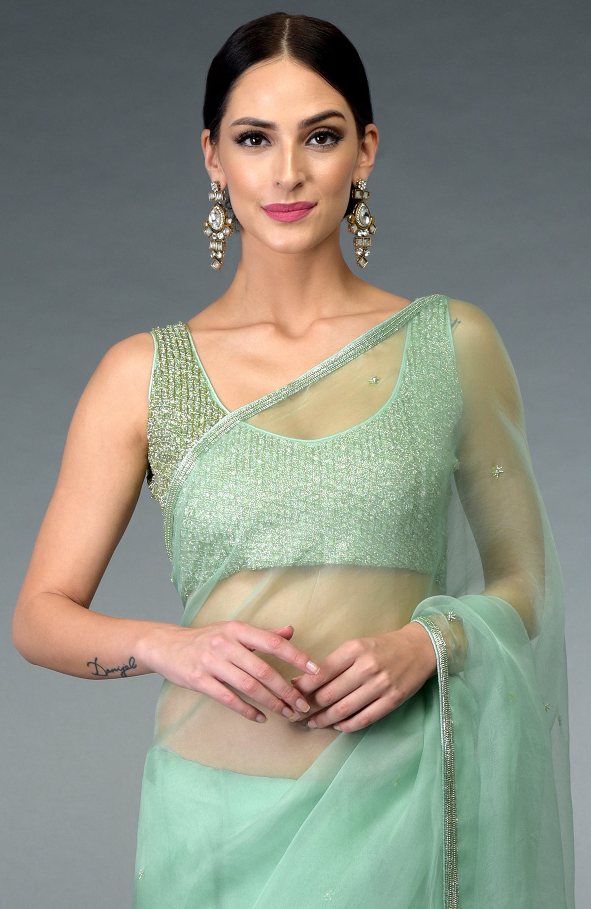 Mint green organza silk saree with a hand-embroidered blouse.