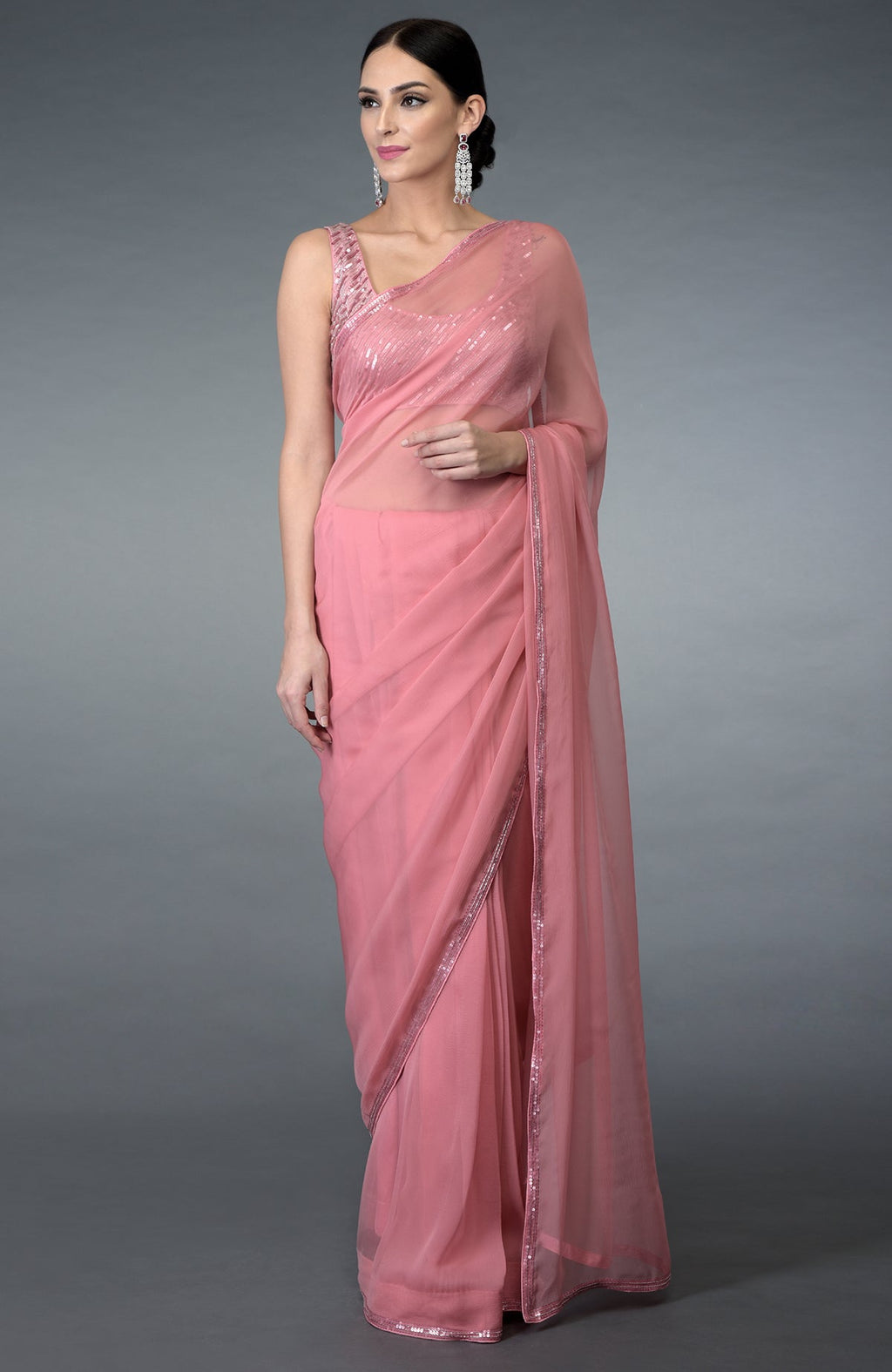 A woman models a pressed rose pure chiffon saree with sequin and beads work.