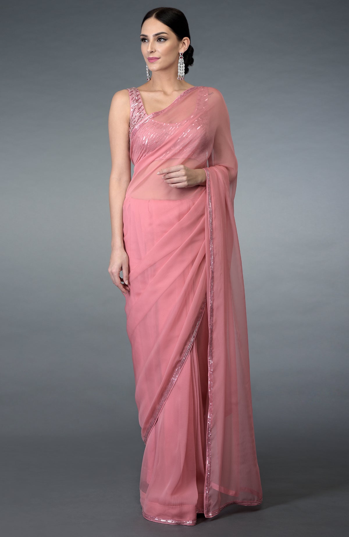 A woman models a pressed rose pure chiffon saree with sequin and beads work.