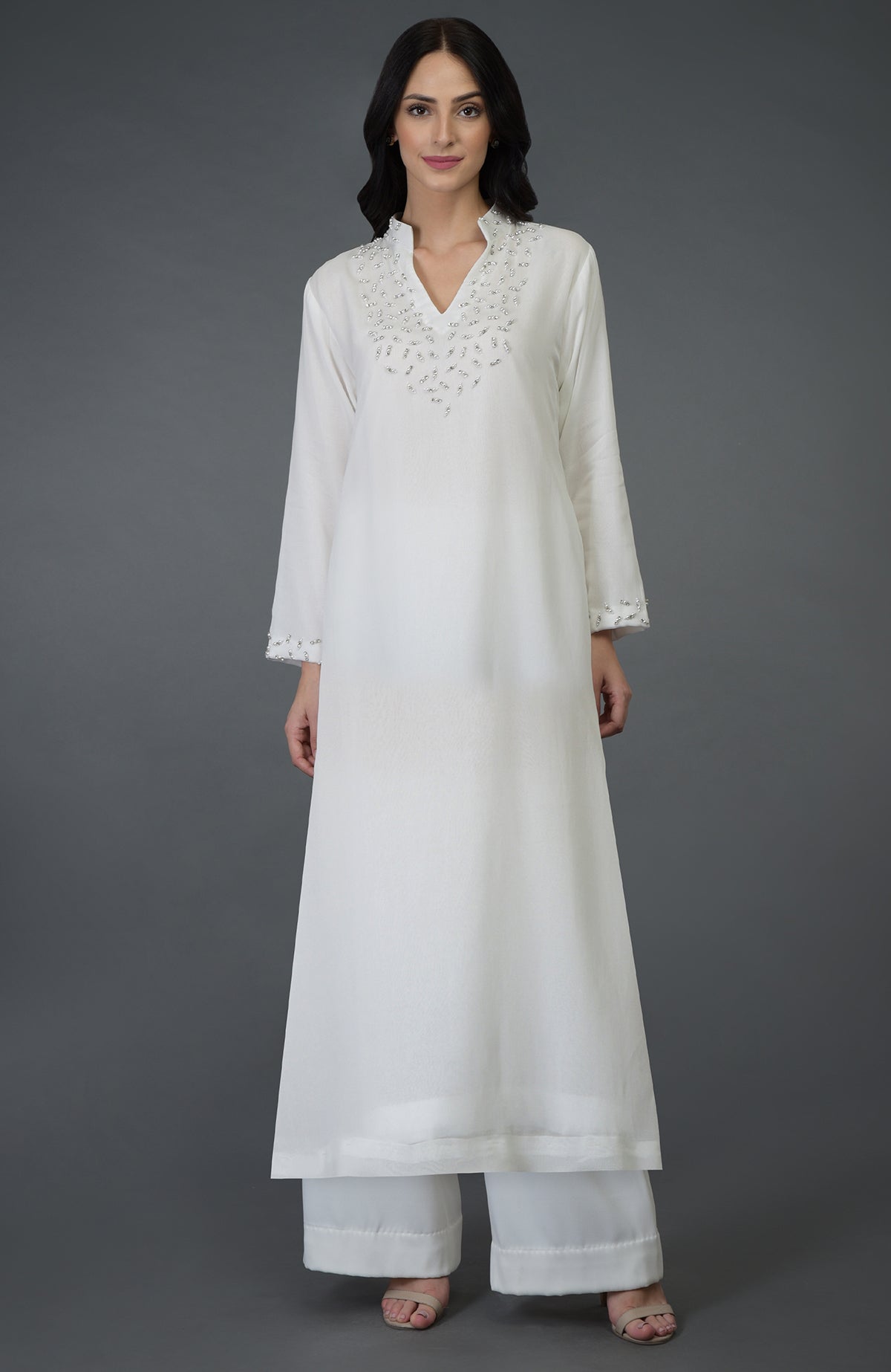 Off-white kurta set with crystal and pearl bead embroidery on the neckline and sleeves.