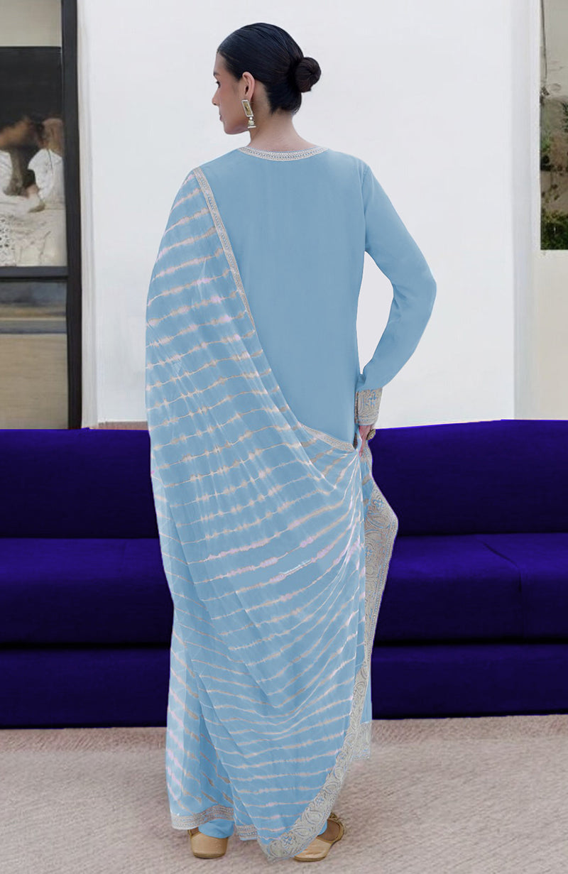 A woman in a cerulean blue kurta set with a leheriya tie-dye dupatta.