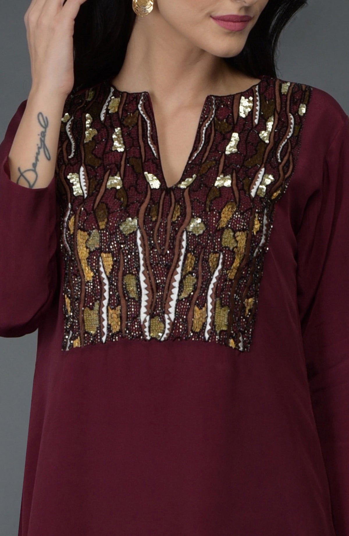 Burgundy kurta with brown, white, and gold sequin and bead embroidery on the yoke.