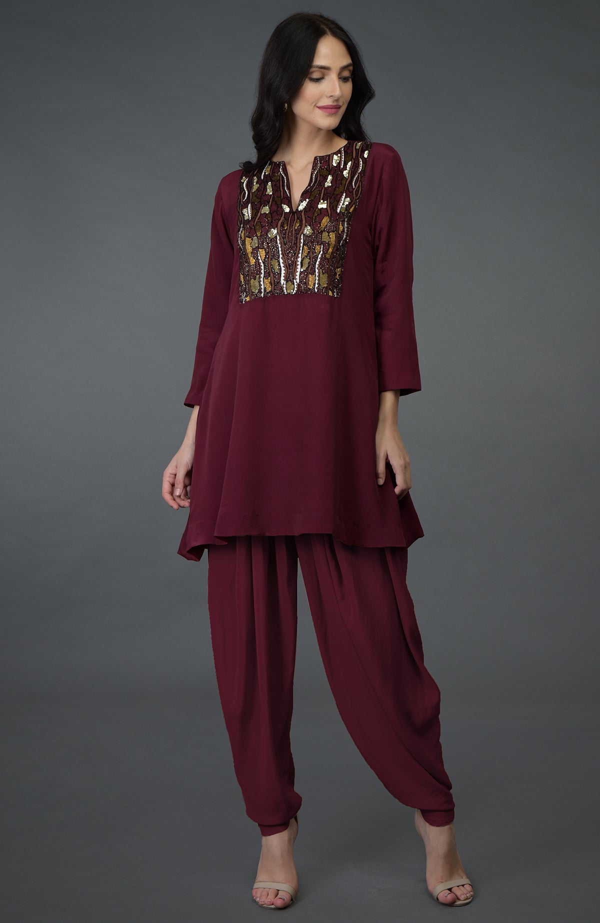 A woman models a burgundy resham sequin and beads embroidered dhoti pants suit.