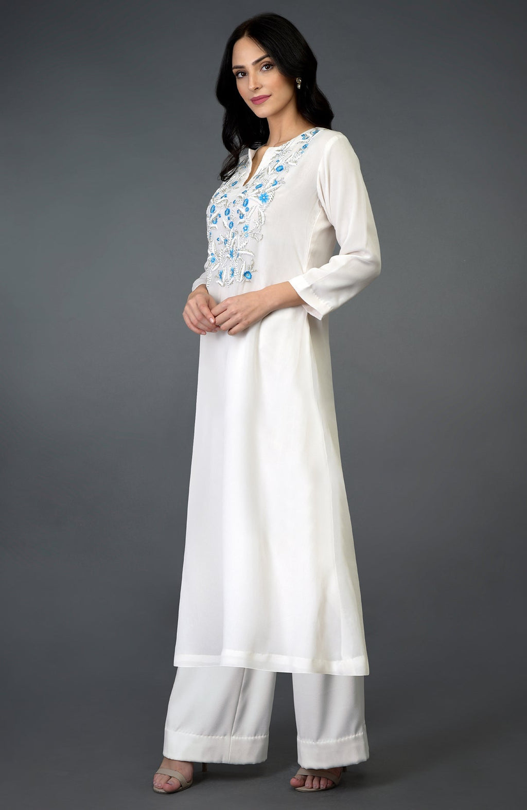 An ivory kurta set with turquoise resham, beads, and crystal embroidery.