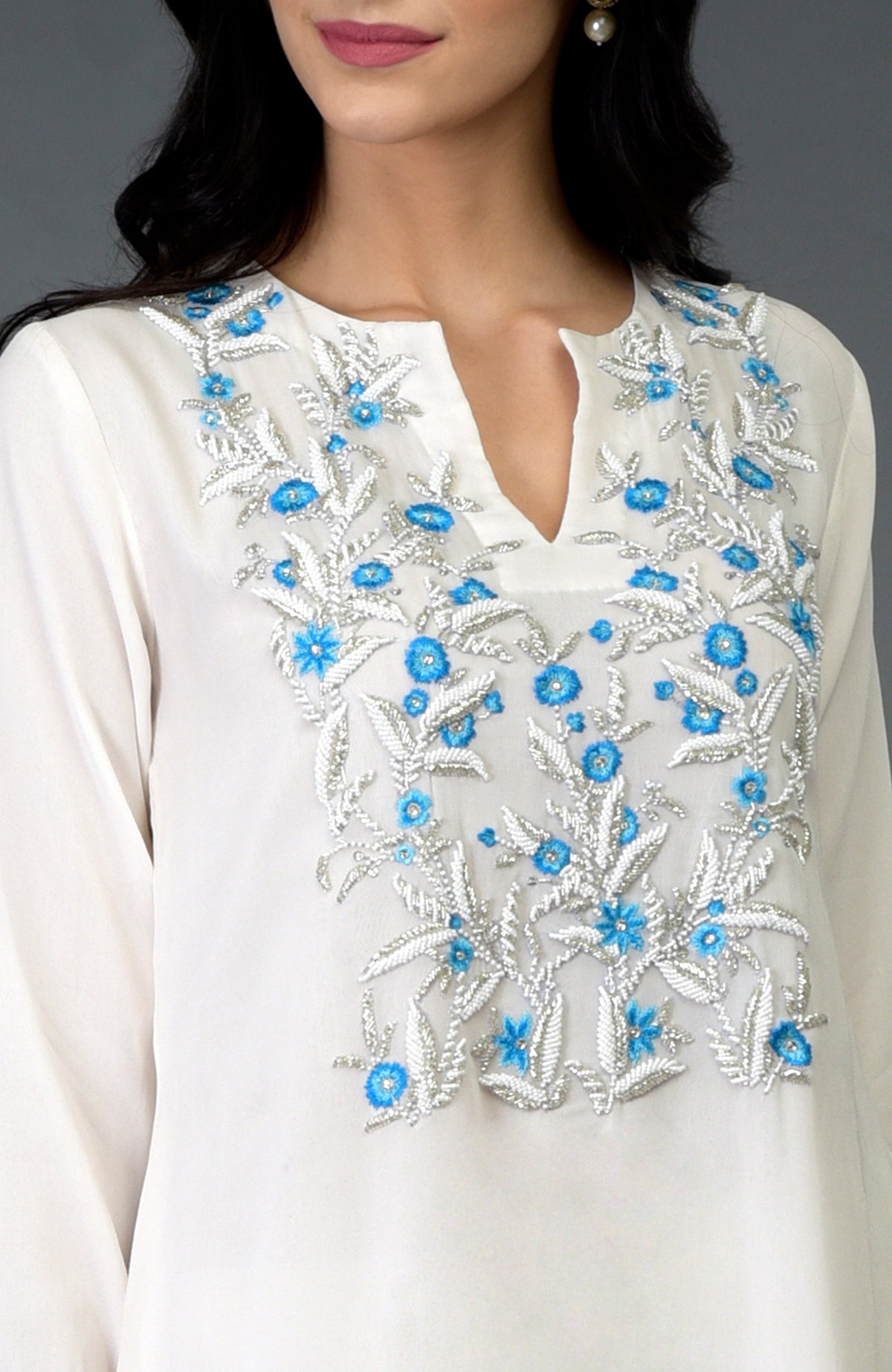 Ivory kurta with turquoise resham, beads, and crystal embroidery on the front yoke.