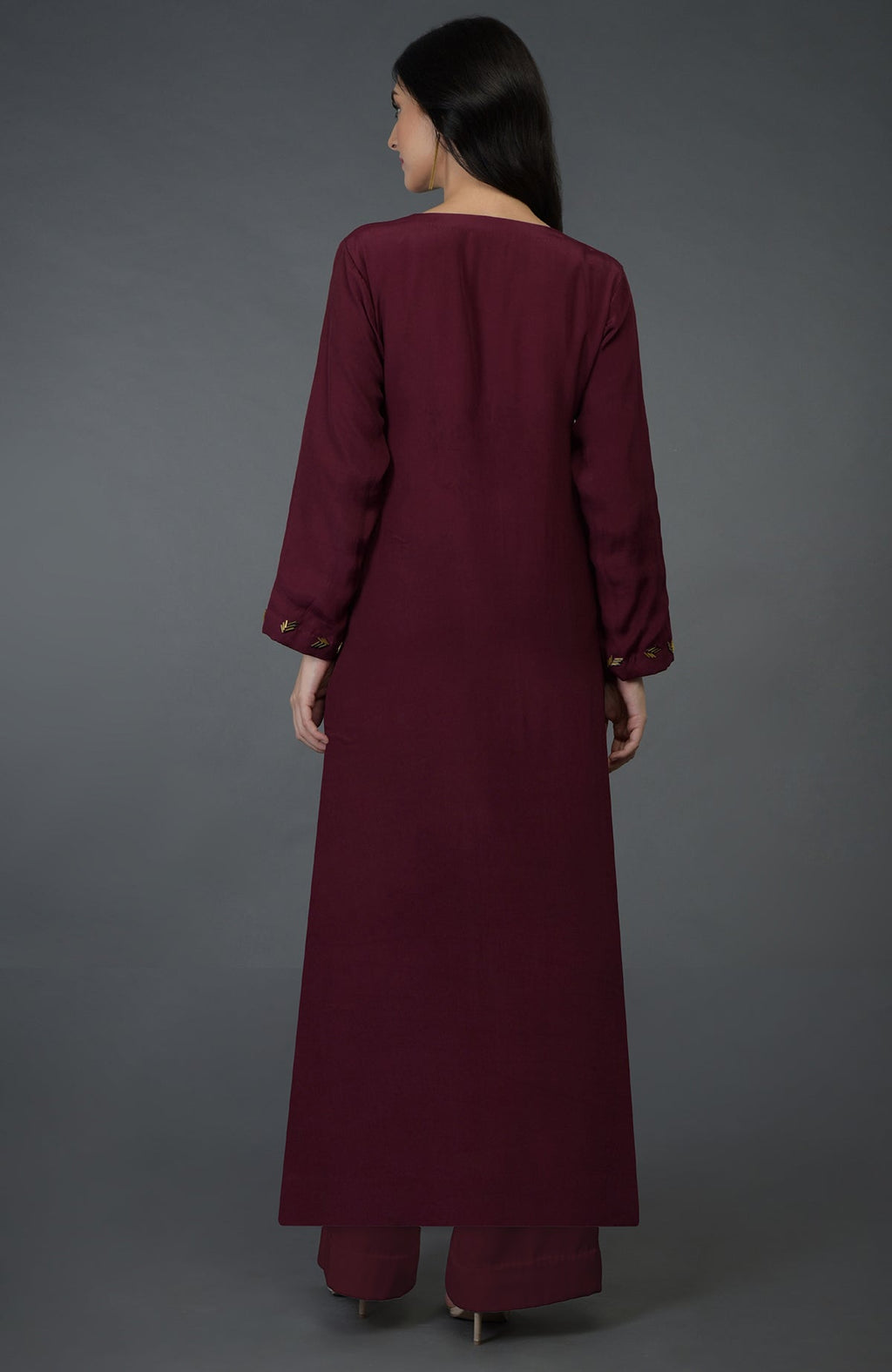 A woman from behind wears a burgundy kurta set with gold bugle bead embroidery.