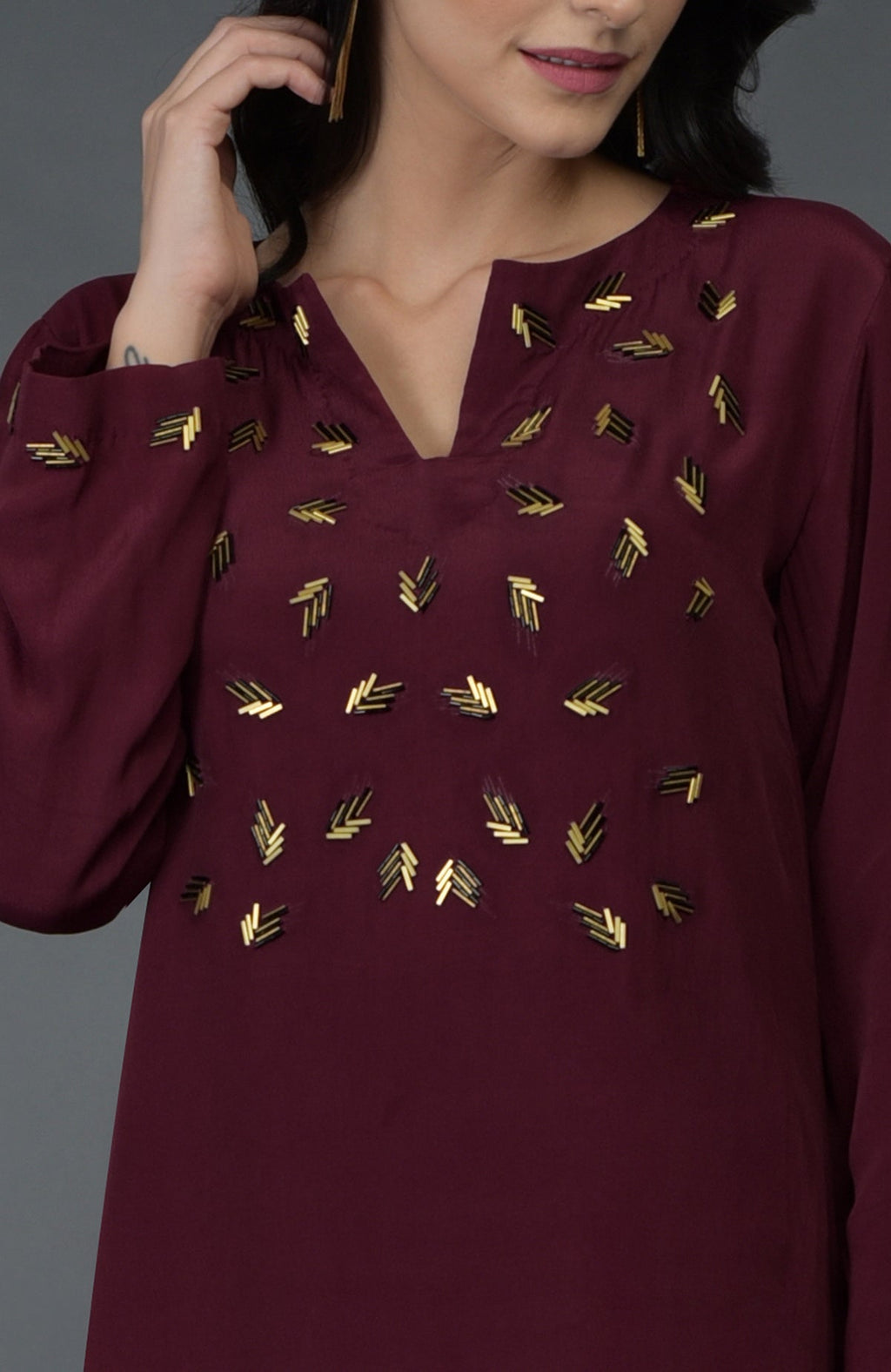 Burgundy kurta with gold and dark bugle bead embroidery on the front and sleeves.