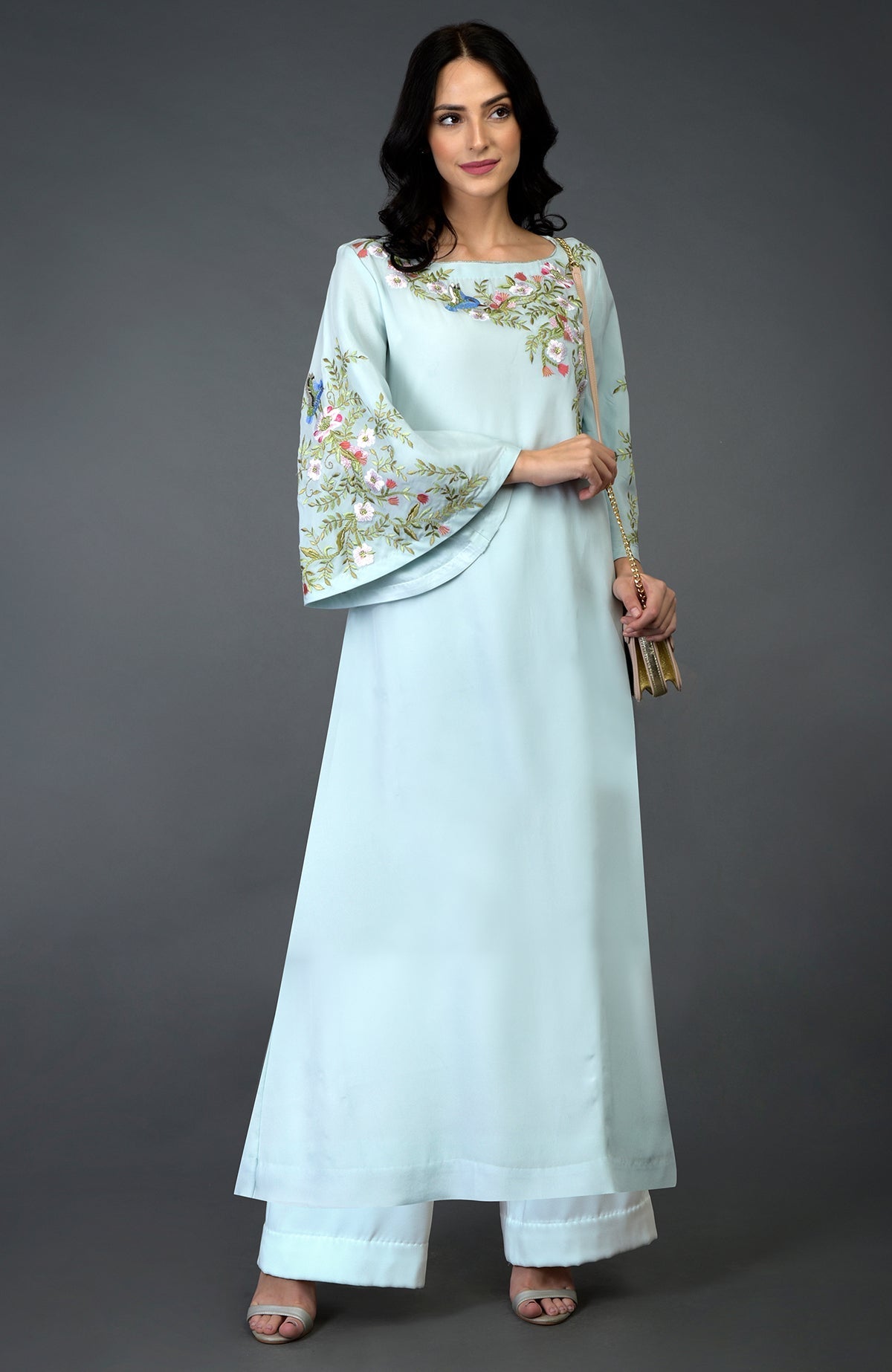 A woman models a serenity blue kurta set with bird and floral embroidery.