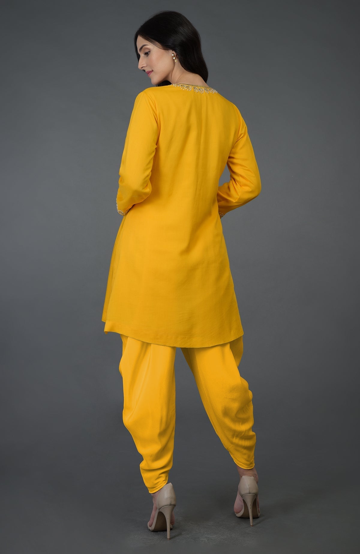 A woman models a yellow dhoti pants suit with embellished neckline and sleeves.