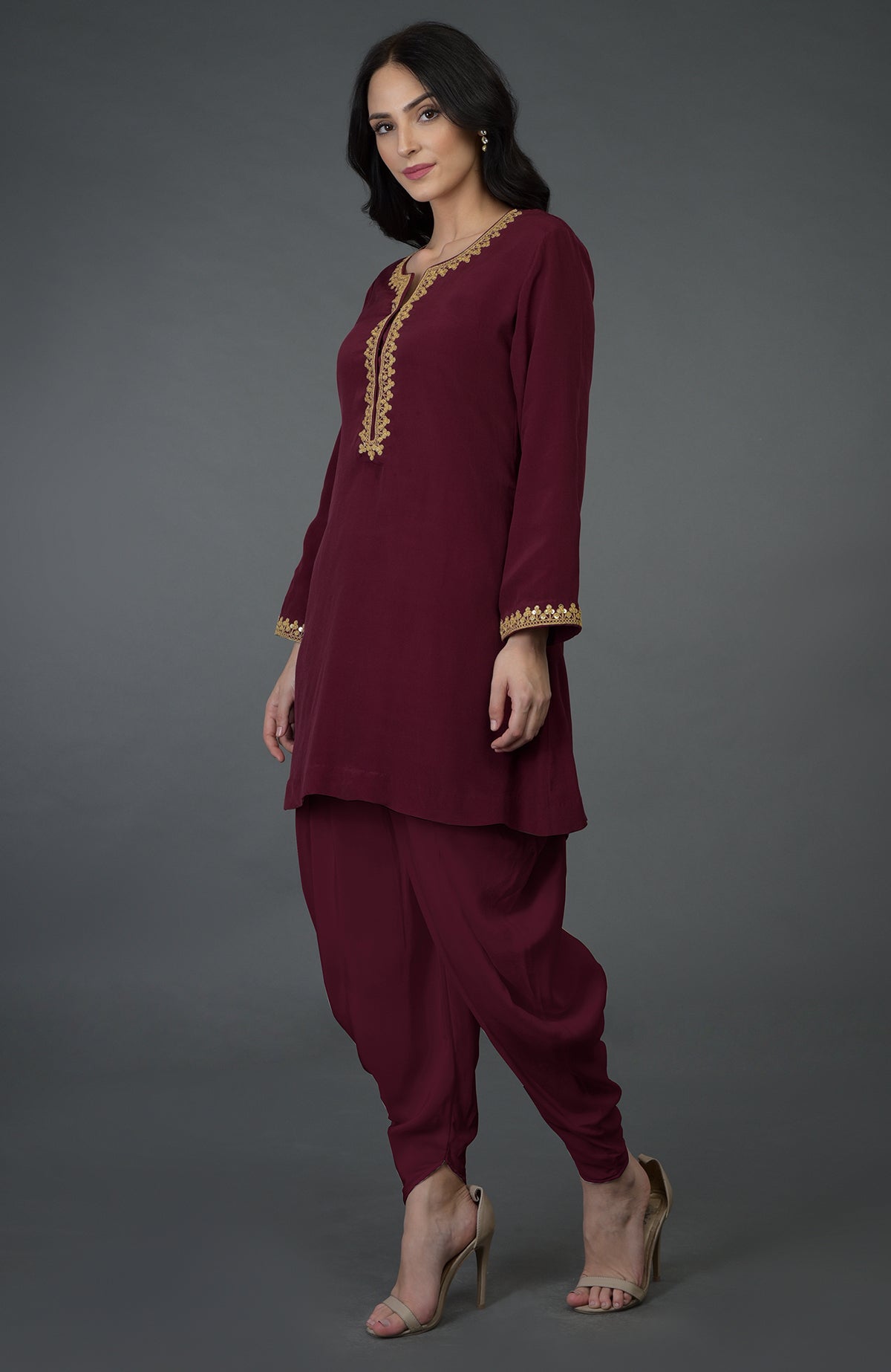 A woman models a burgundy marori and sequin embroidered dhoti pants suit.