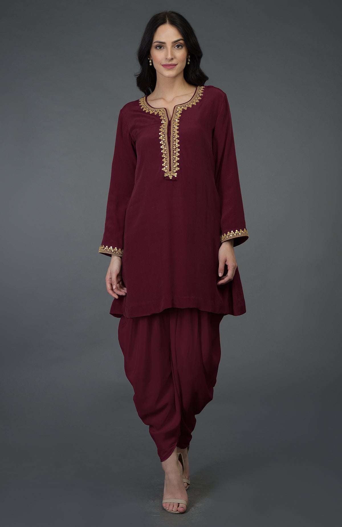 A woman models a burgundy marori and sequin embroidered dhoti pants suit.
