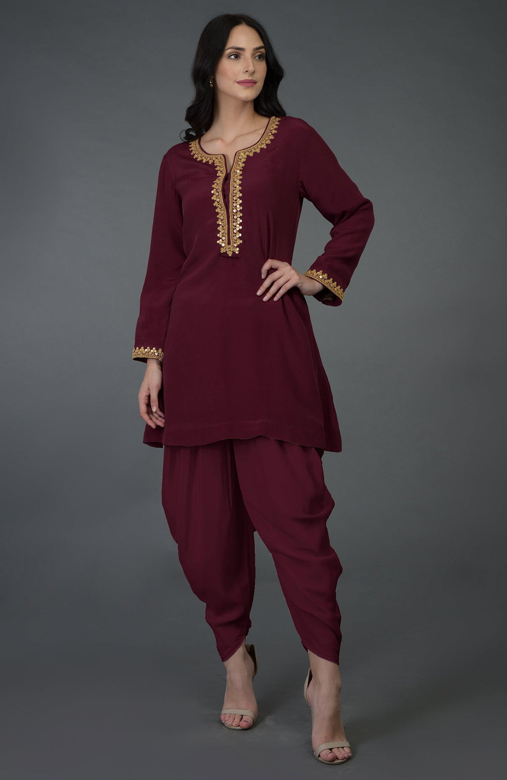 A woman models a burgundy marori and sequin embroidered dhoti pants suit.