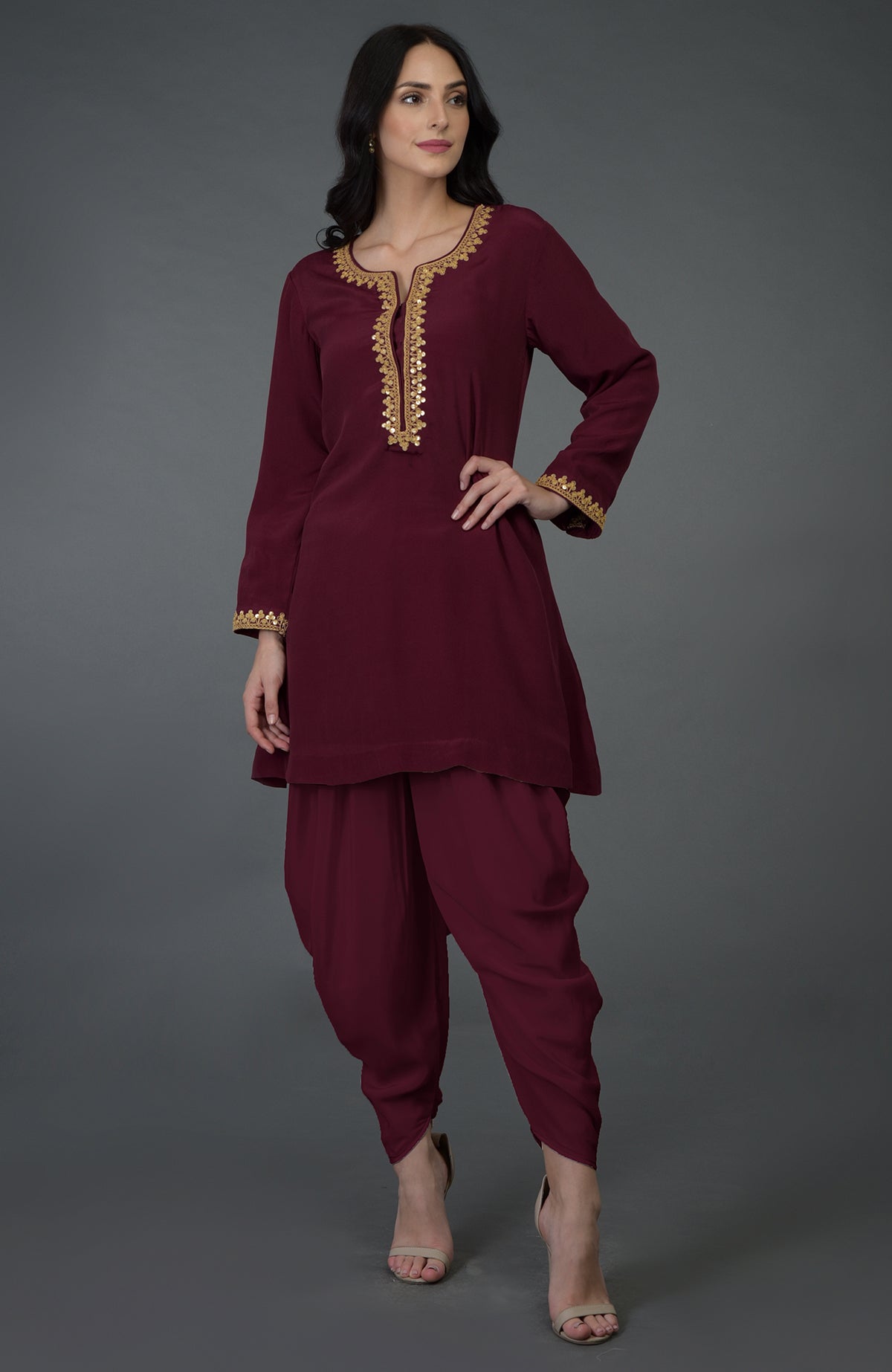 A woman models a burgundy marori and sequin embroidered dhoti pants suit.