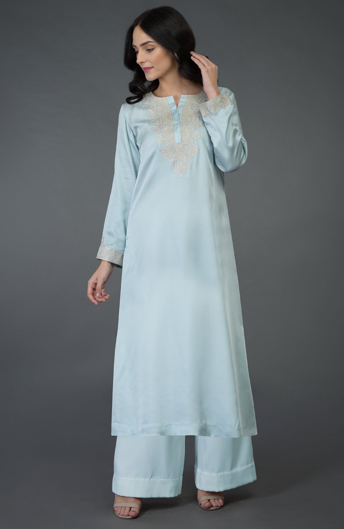 A woman models a serenity blue Kashmiri tilla embroidered kurta set with wide-leg pants.