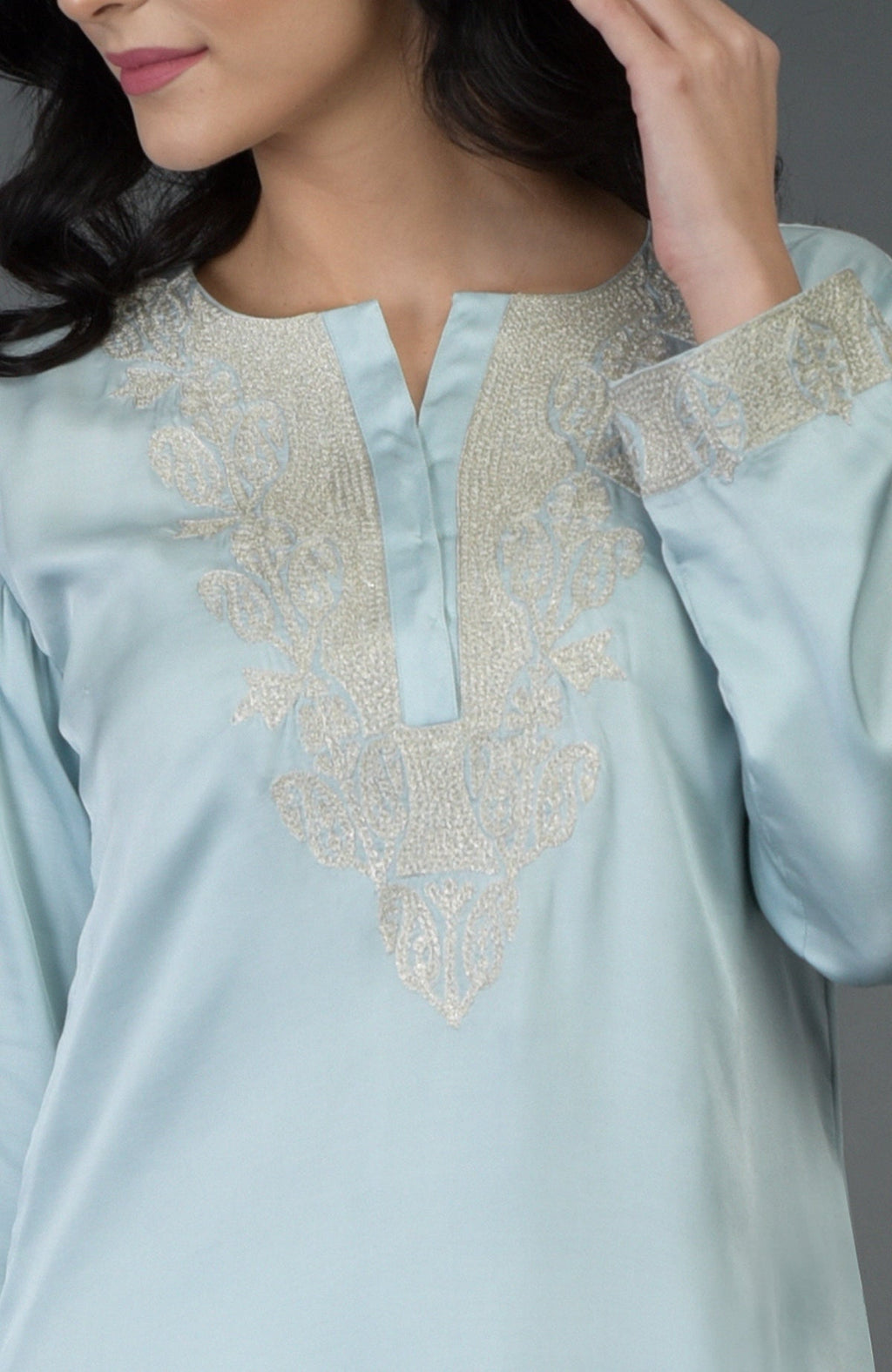 A woman models a serenity blue Kashmiri tilla embroidered kurta with silver embroidery.