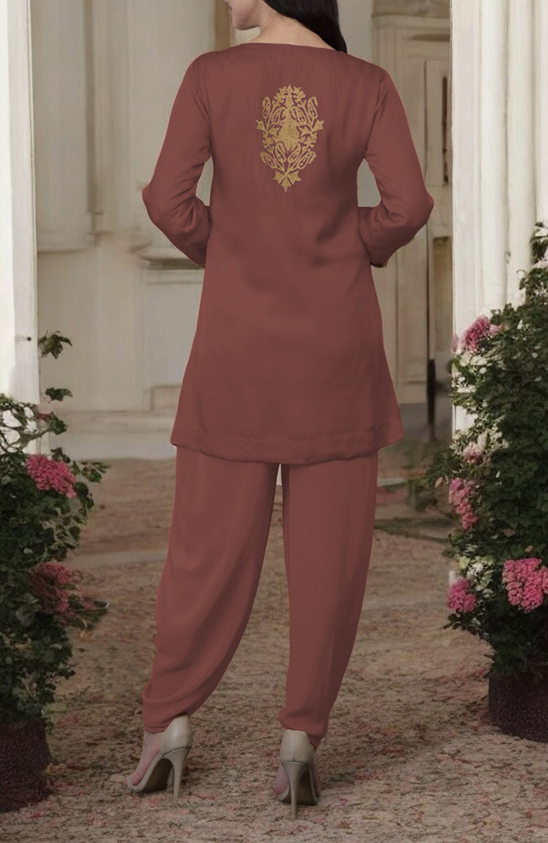 A woman from behind wears a chutney-colored dhoti pants suit with gold Kashmiri tilla embroidery.