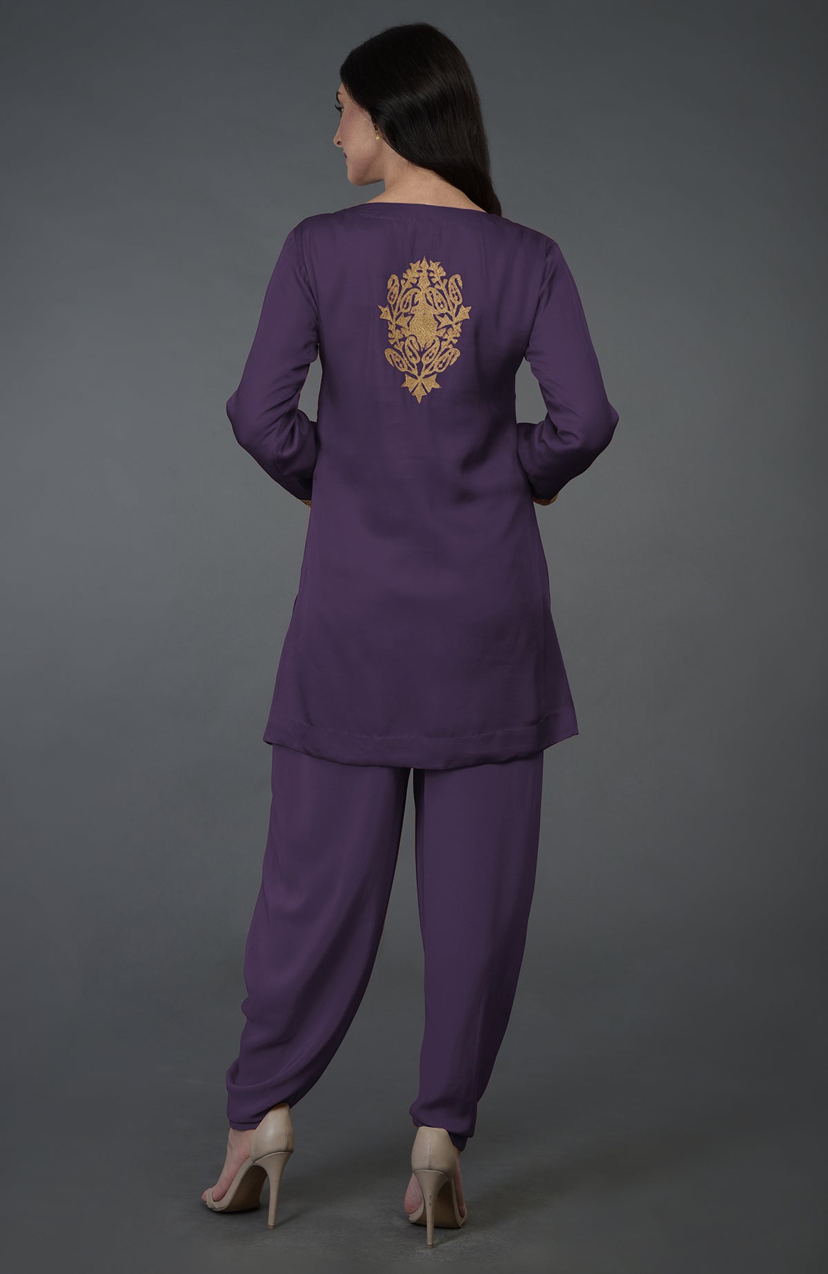 A woman models a mulled grape Kashmiri tilla embroidered dhoti pants suit.