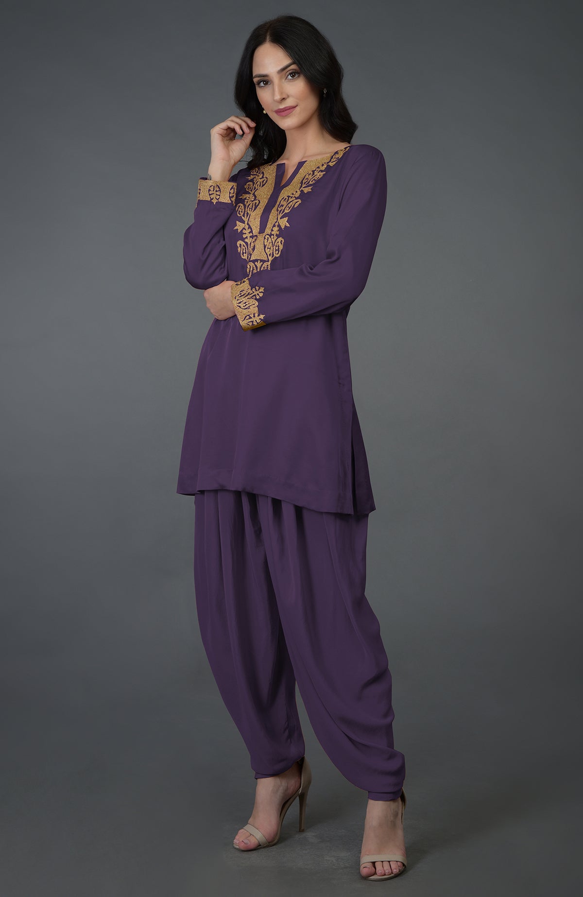 A woman models a mulled grape Kashmiri tilla embroidered dhoti pants suit.