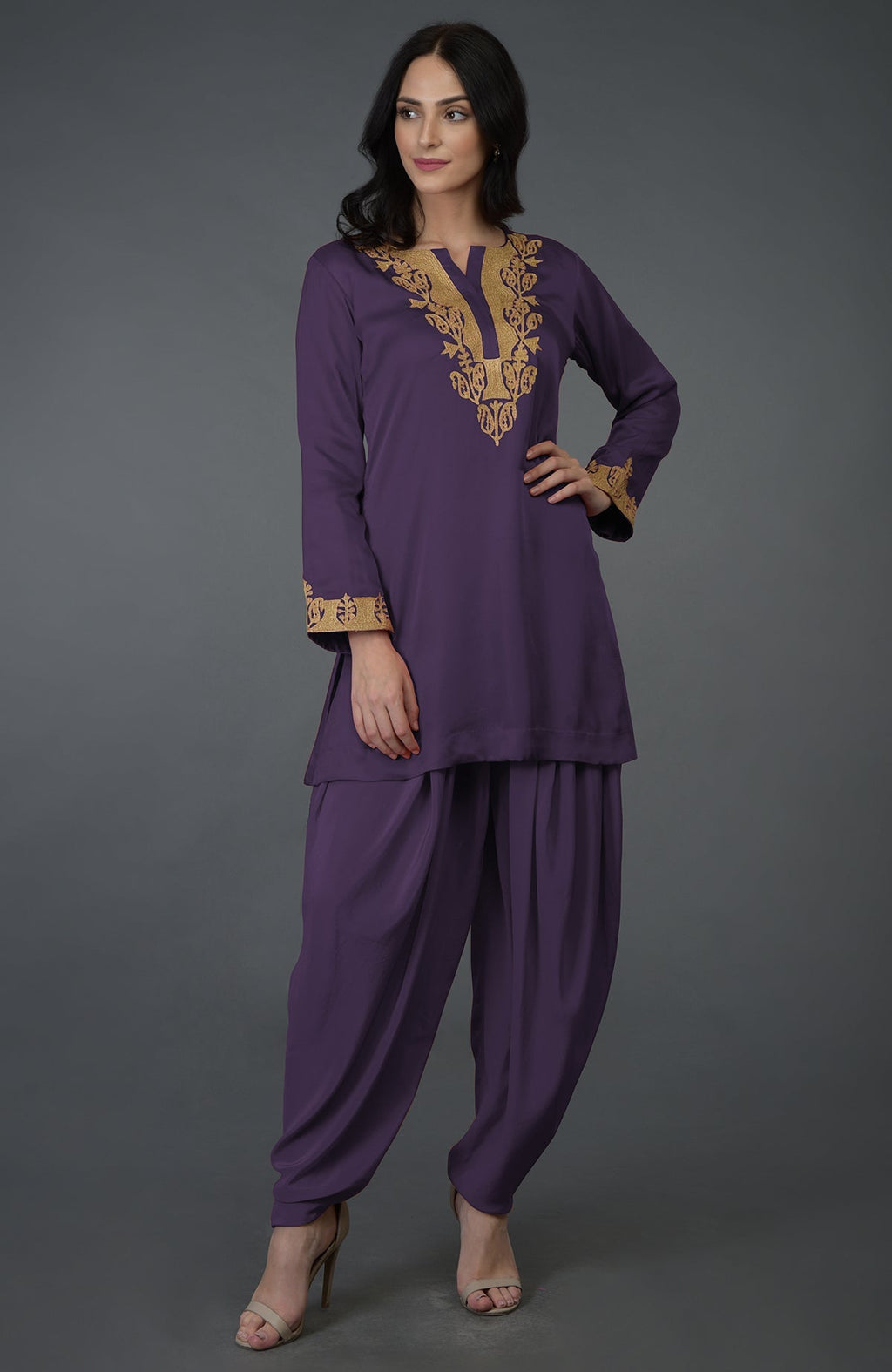 A woman models a mulled grape Kashmiri tilla embroidered dhoti pants suit.