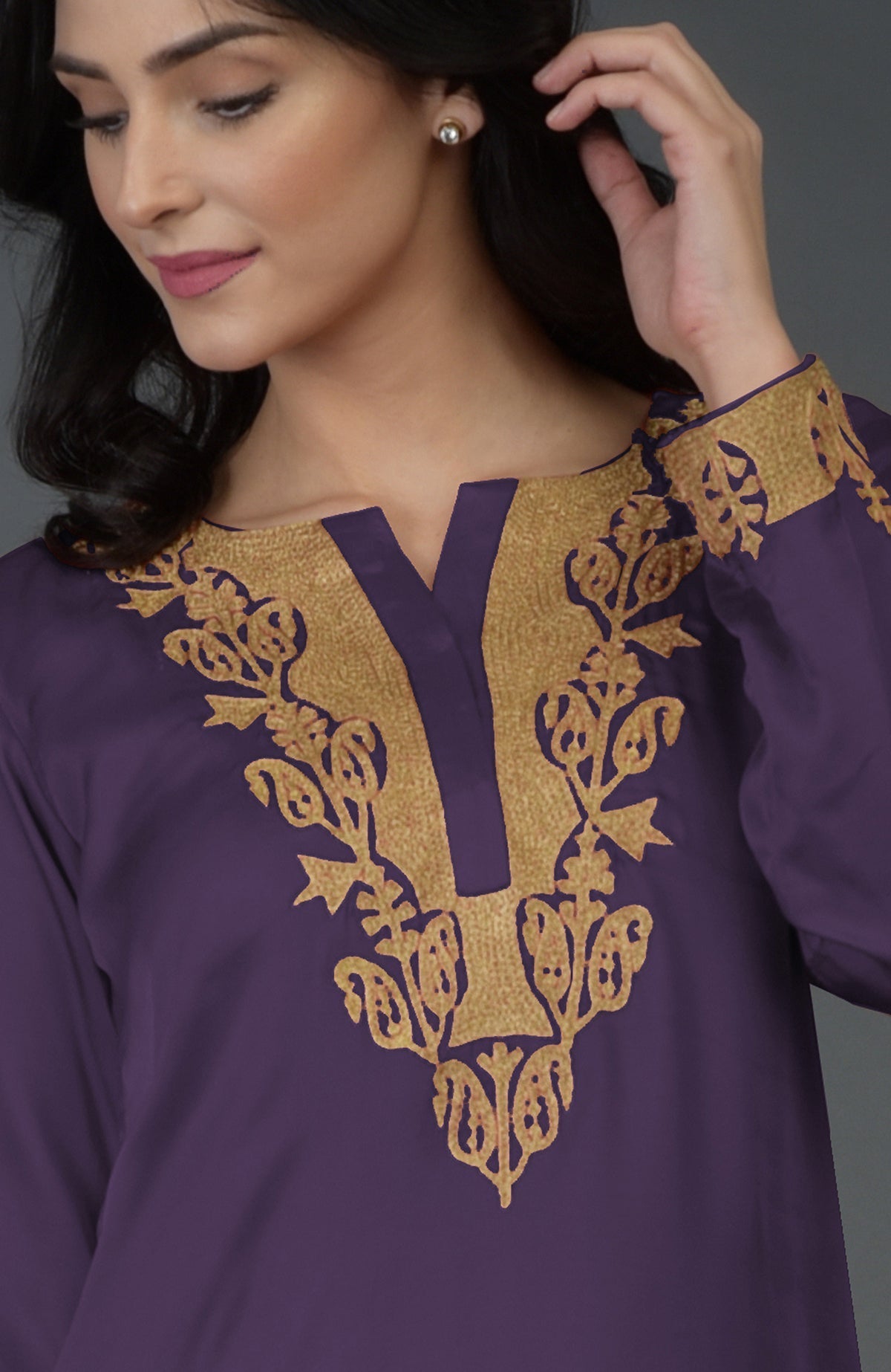A woman models a mulled grape Kashmiri Tilla embroidered dhoti pants suit.