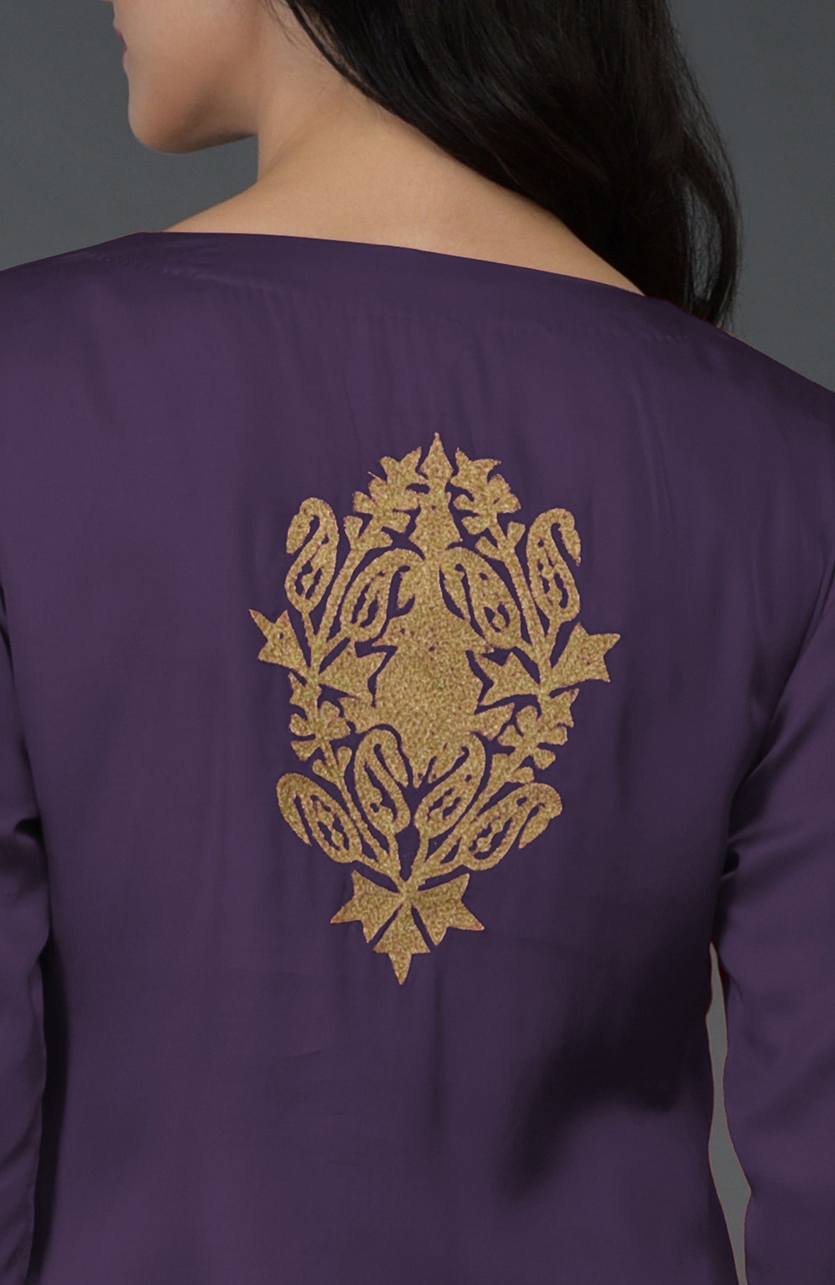 A woman from the back wearing a purple kurta with gold Kashmiri tilla embroidery.