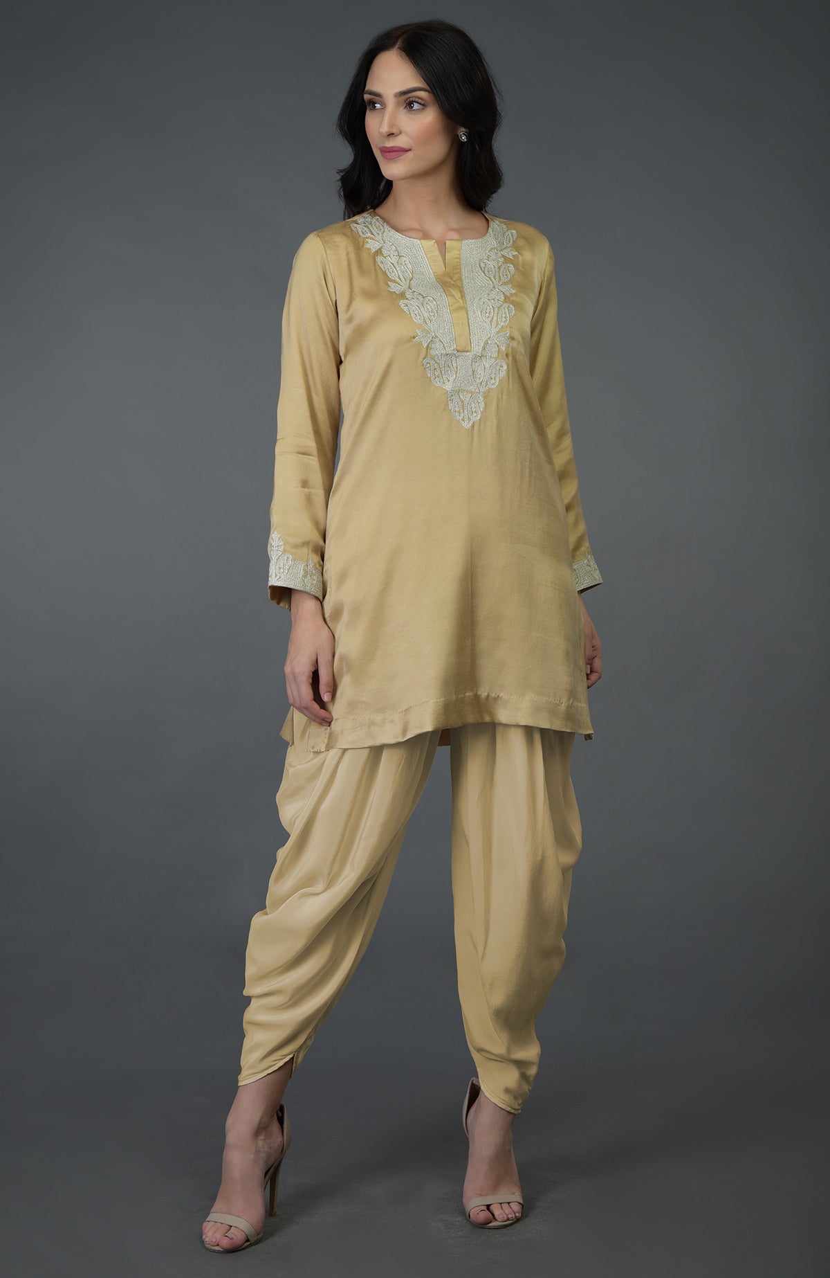 A woman models a beige gold Kashmiri tilla embroidered dhoti pants suit.
