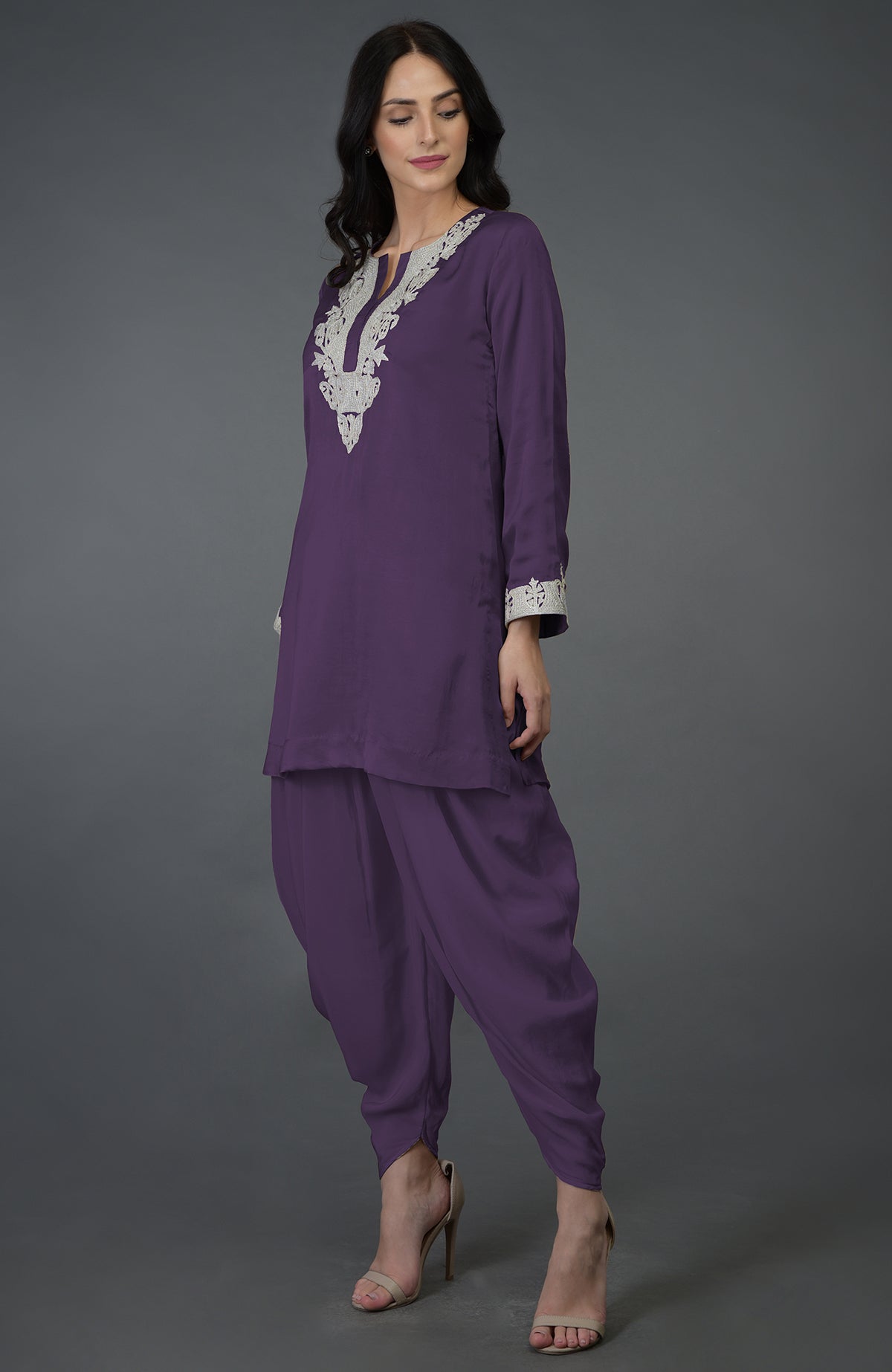 A woman models a mulled grape Kashmiri tilla embroidered dhoti pants suit.
