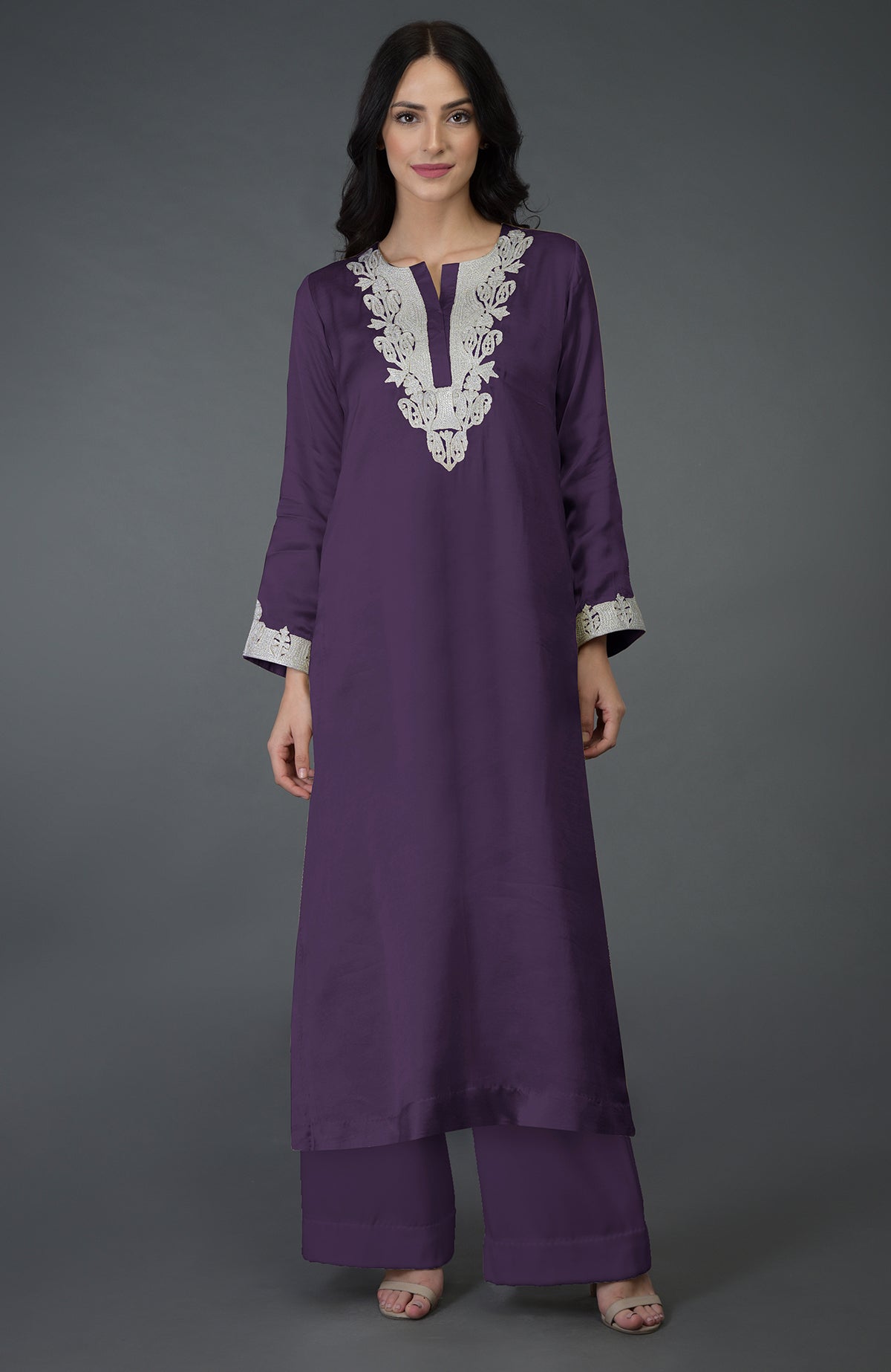 A woman models an iris blue Kashmiri tilla embroidered kurta set with palazzo pants.