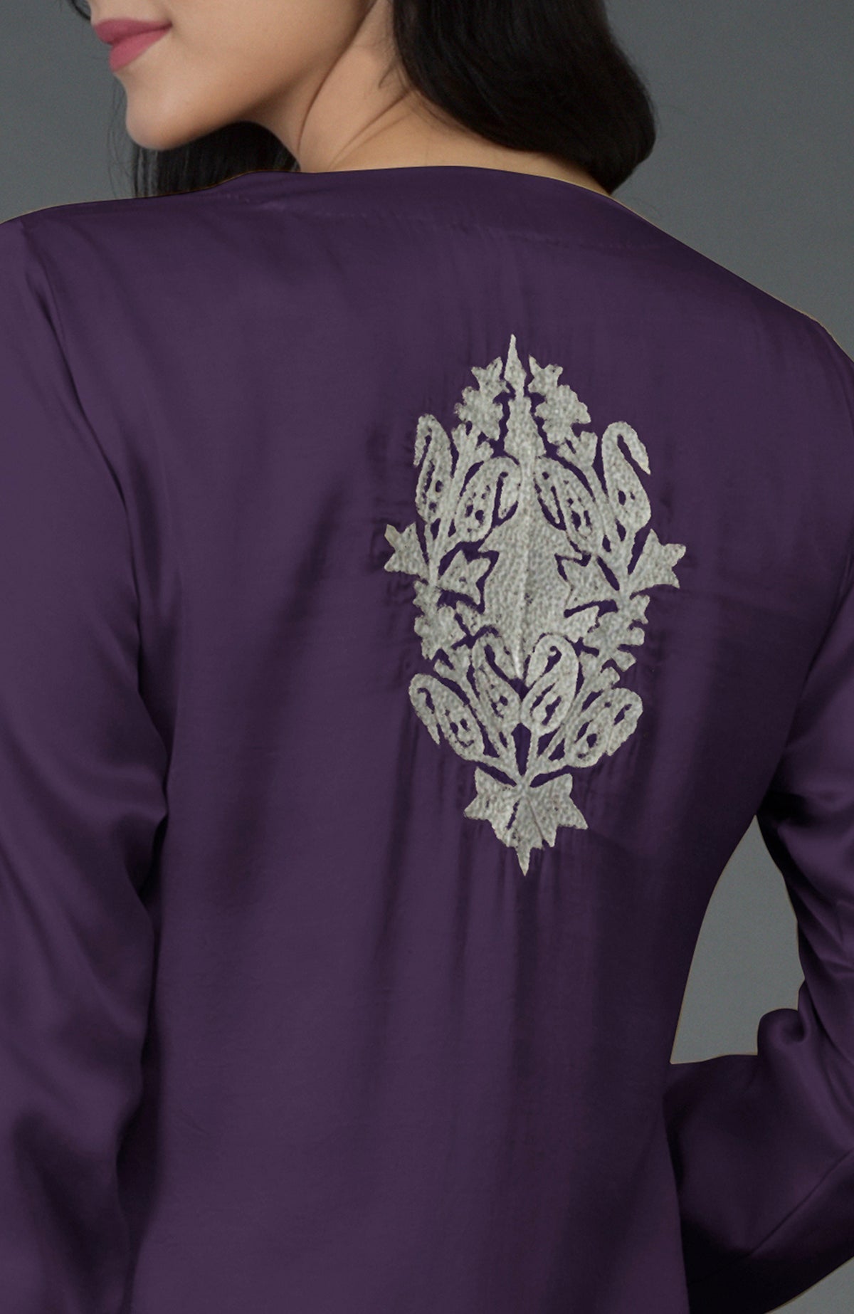 A woman from the back wearing a purple kurta with silver Kashmiri tilla embroidery.