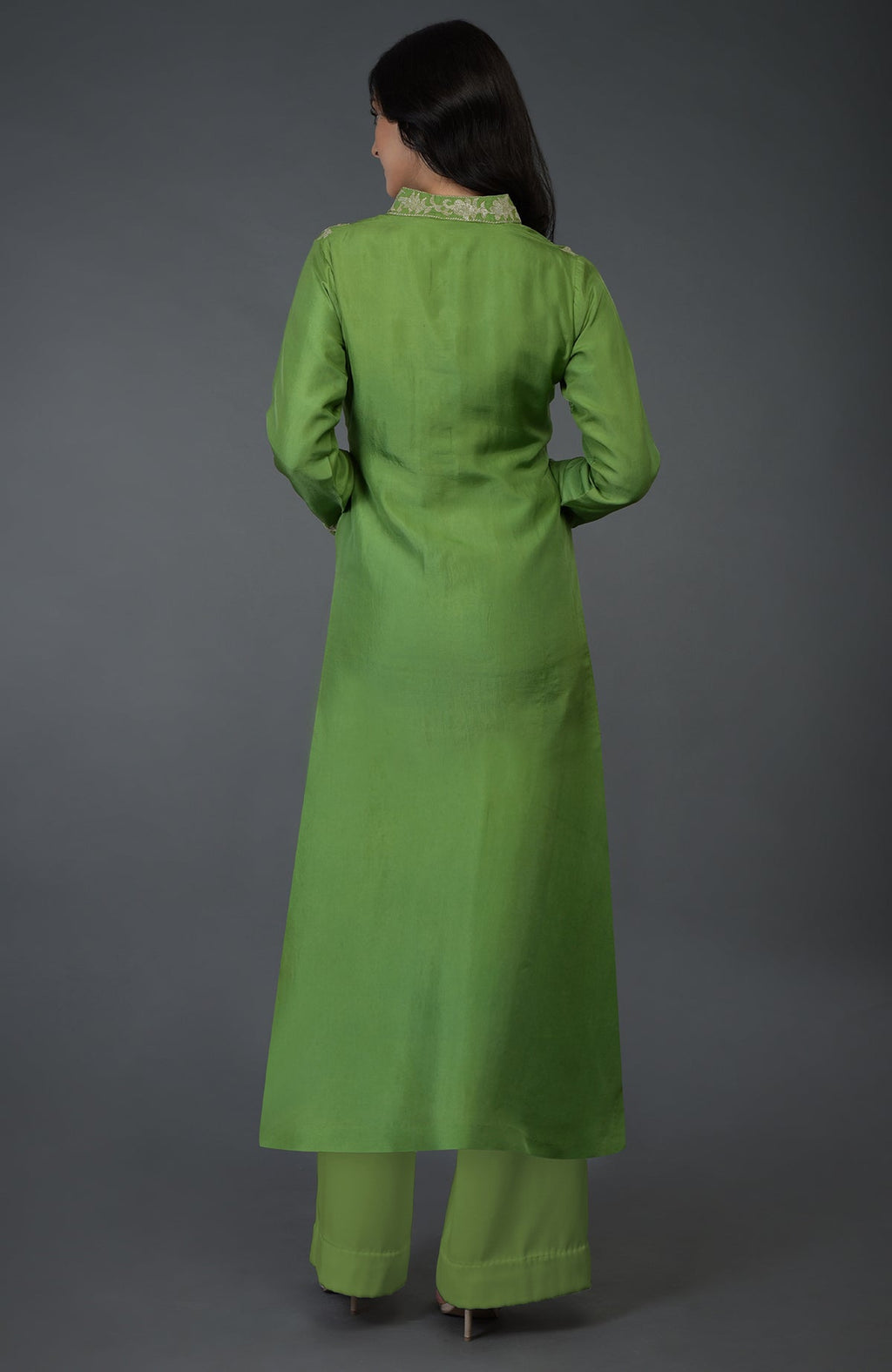 A woman from behind wears a green kurta set with Kashmiri tilla embroidery.