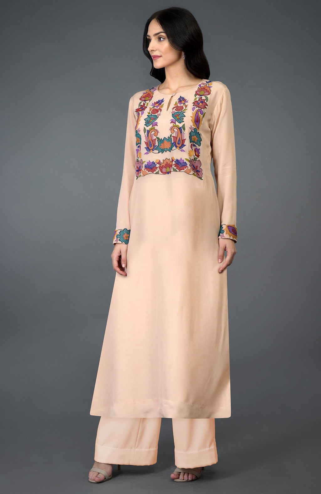A woman models a tea rose kani art embroidered kurta set.