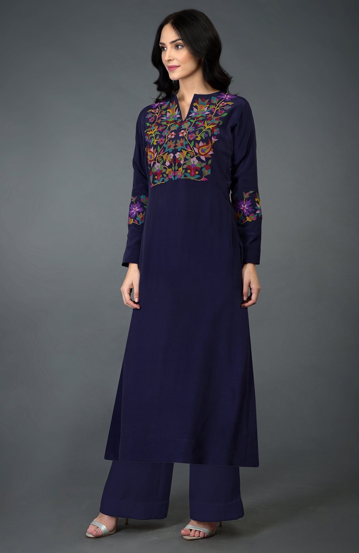 A woman models an eclipse blue kurta set with colorful Kani art embroidery.
