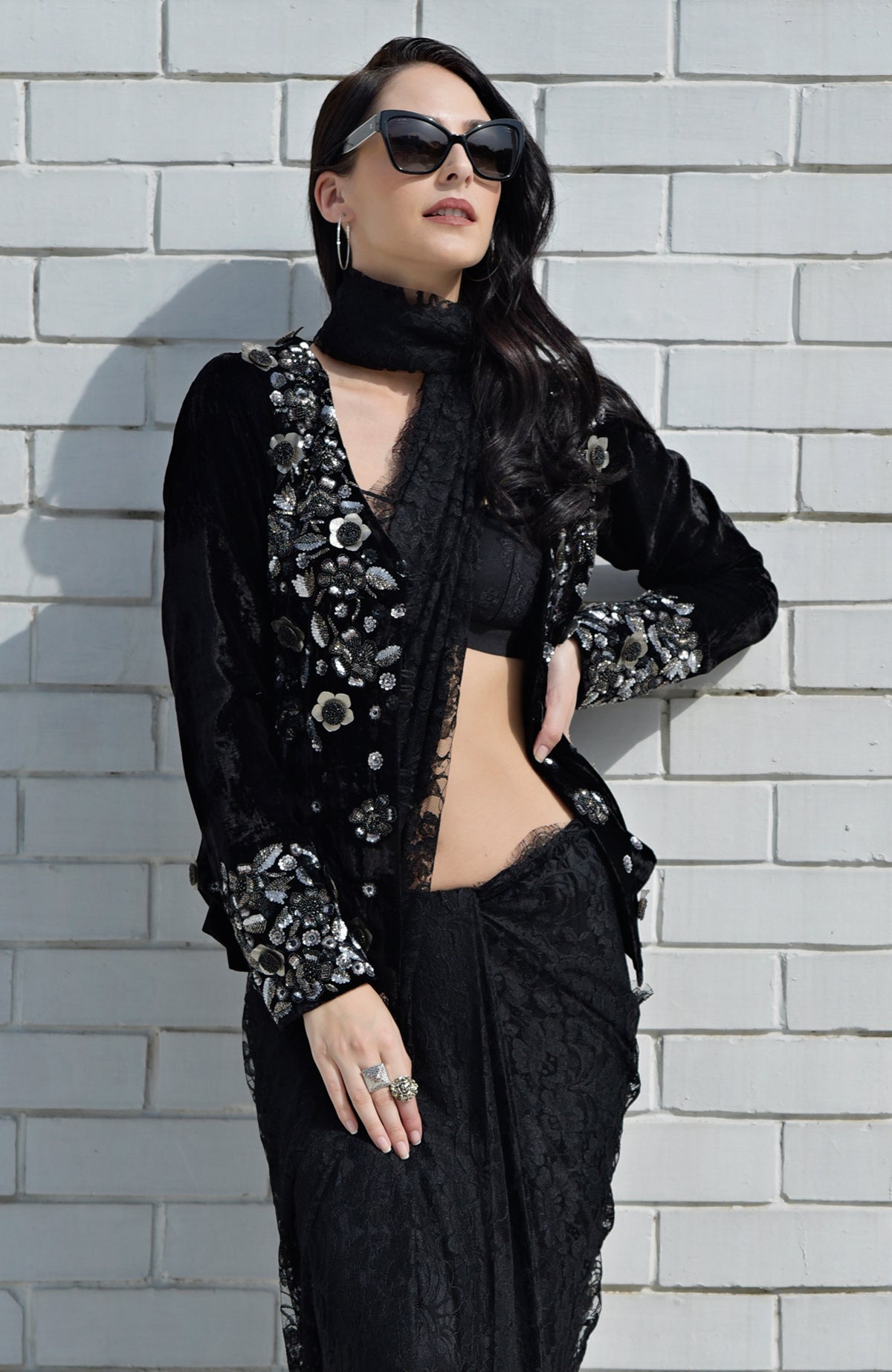 Black velvet jacket with metallic floral embroidery, paired with a black lace saree.