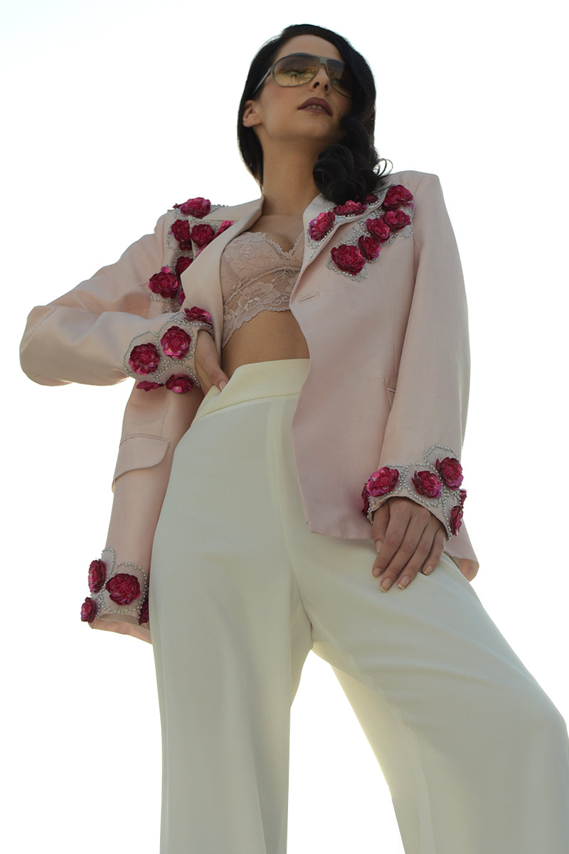 Pale pink silk jacket with 3D floral hand embroidery and white wide-leg pants.