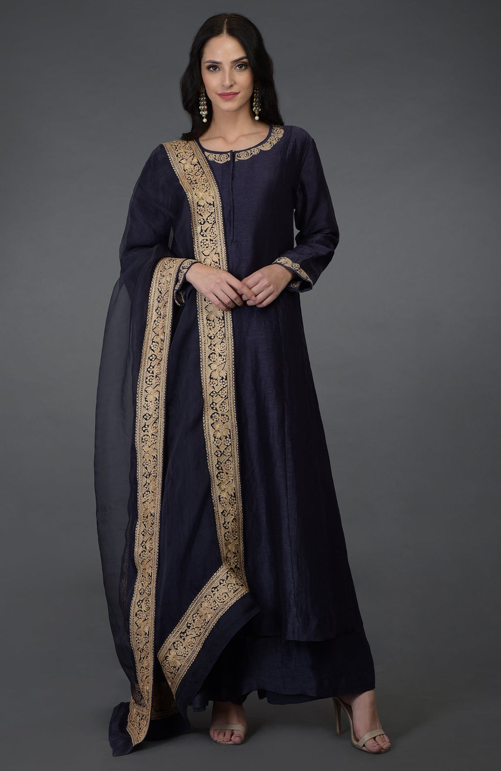 A woman models an eclipse blue tilla embroidered suit with gold accents.