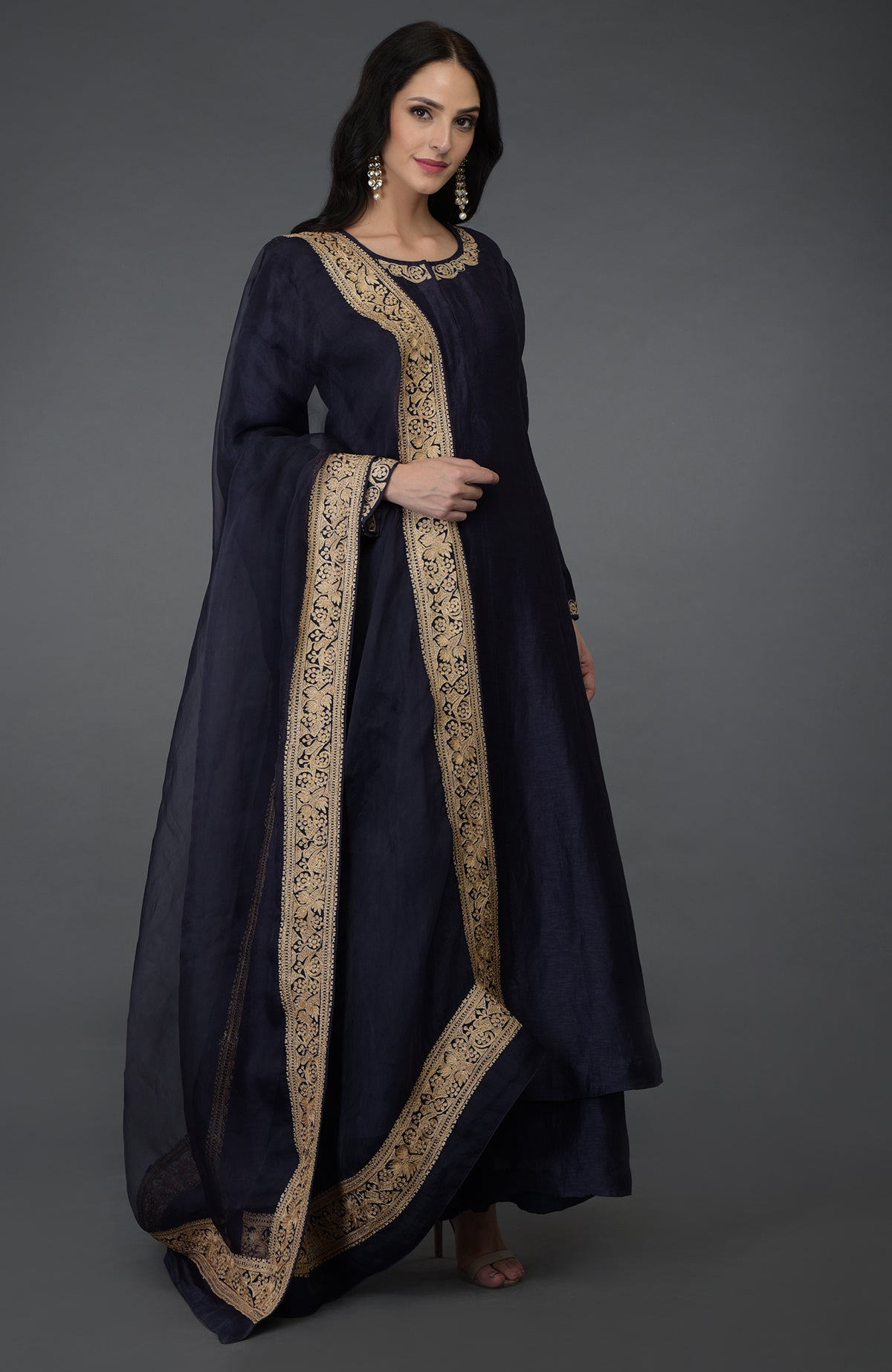 A woman models an eclipse blue tilla embroidered suit with gold accents.