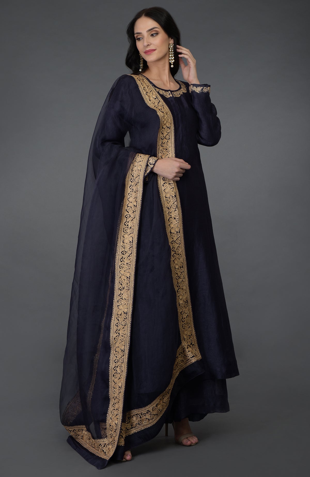 A woman models an eclipse blue tilla embroidered suit with gold accents.