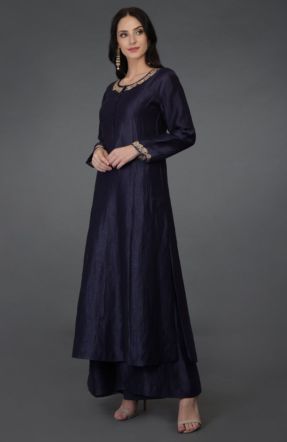 A woman models an eclipse blue tilla embroidered suit with gold accents.