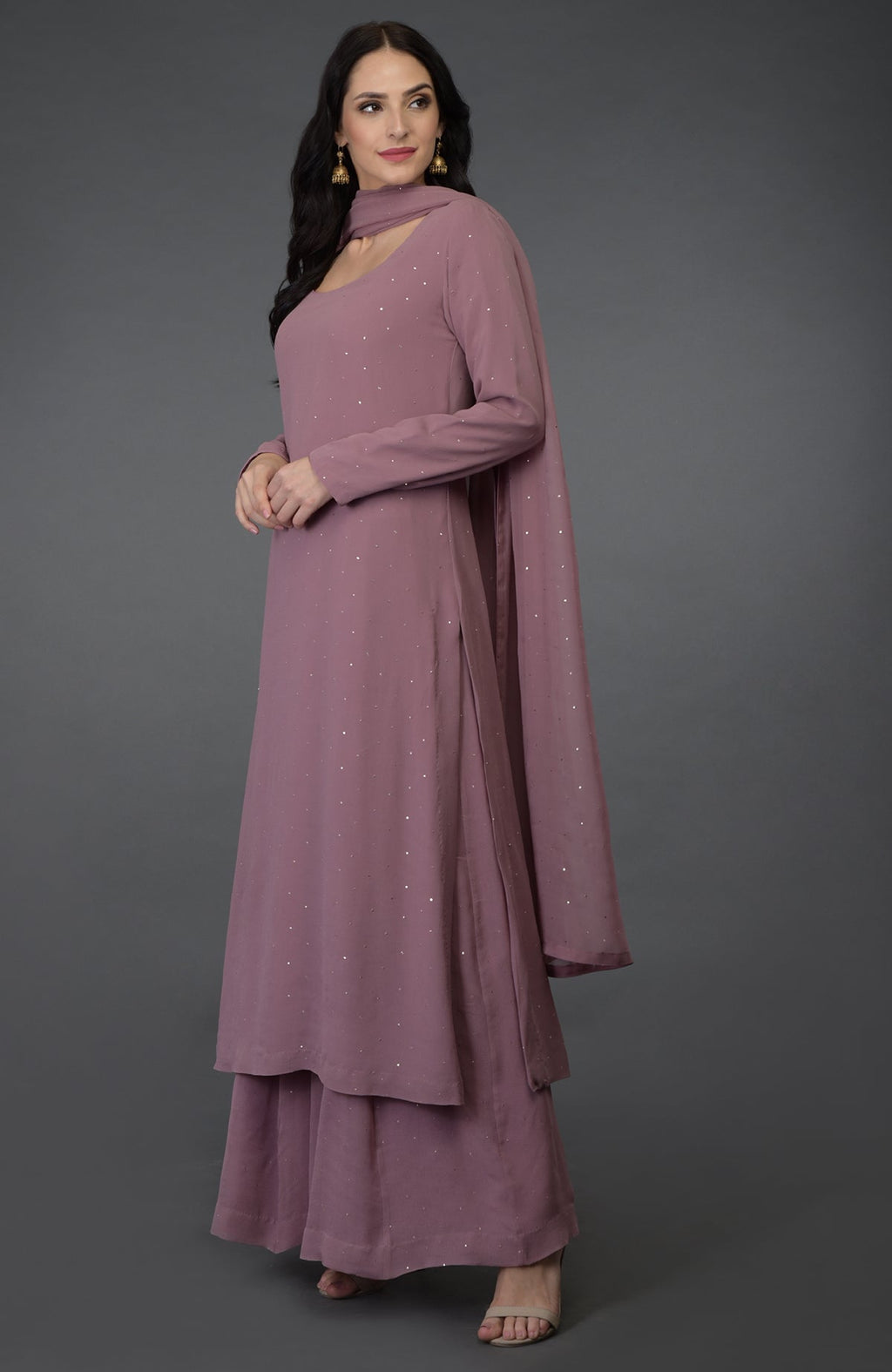 A woman models a lilac handcrafted mukaish farshi palazzo suit with a dupatta.