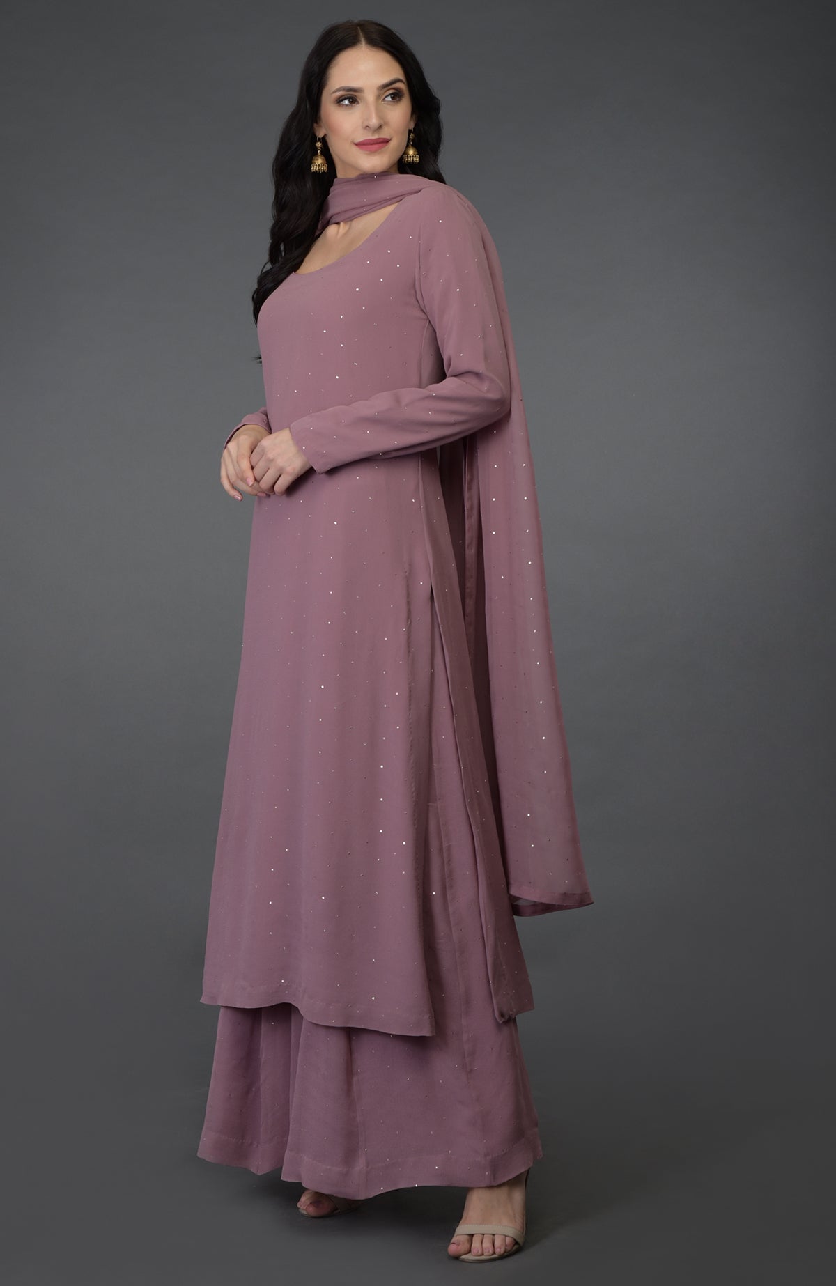 A woman models a lilac handcrafted mukaish farshi palazzo suit with a dupatta.