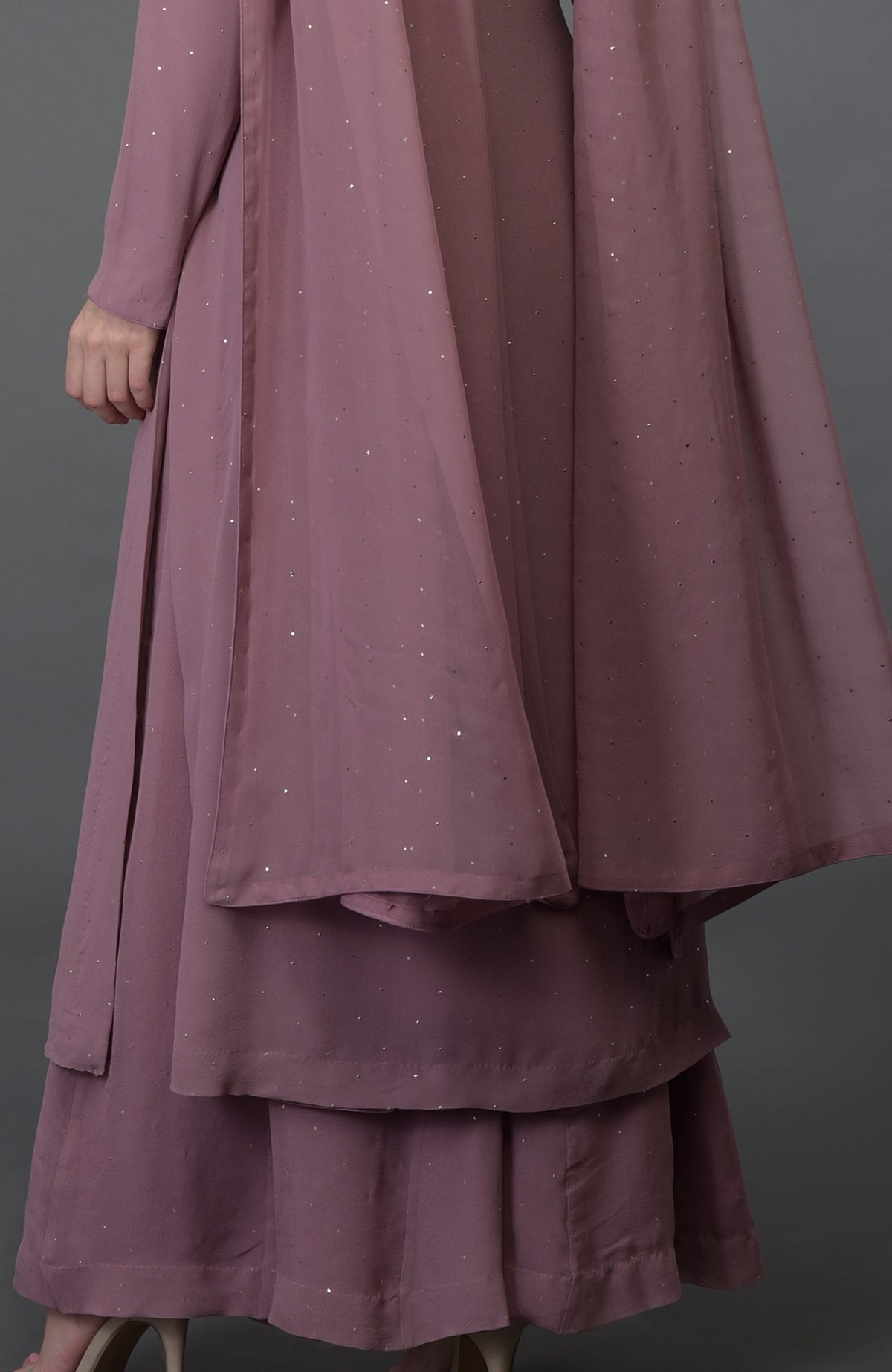 A woman models a lilac handcrafted mukaish farshi palazzo suit.