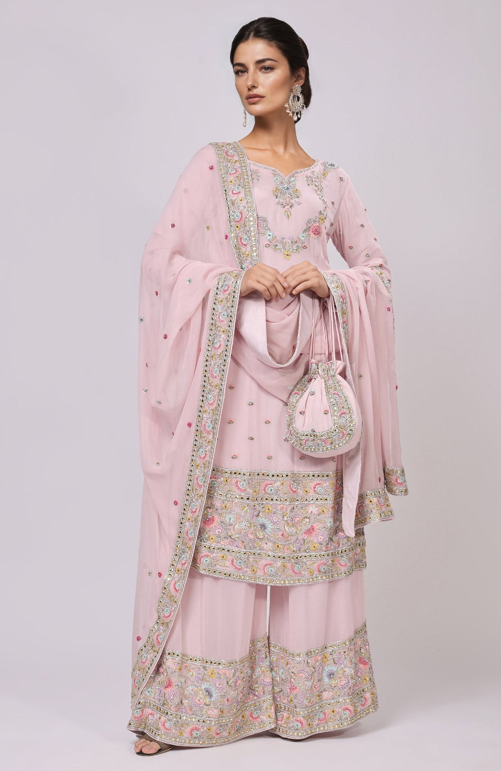 Marshmallow pink sharara set with resham and zardozi embroidery, and a matching potli bag.